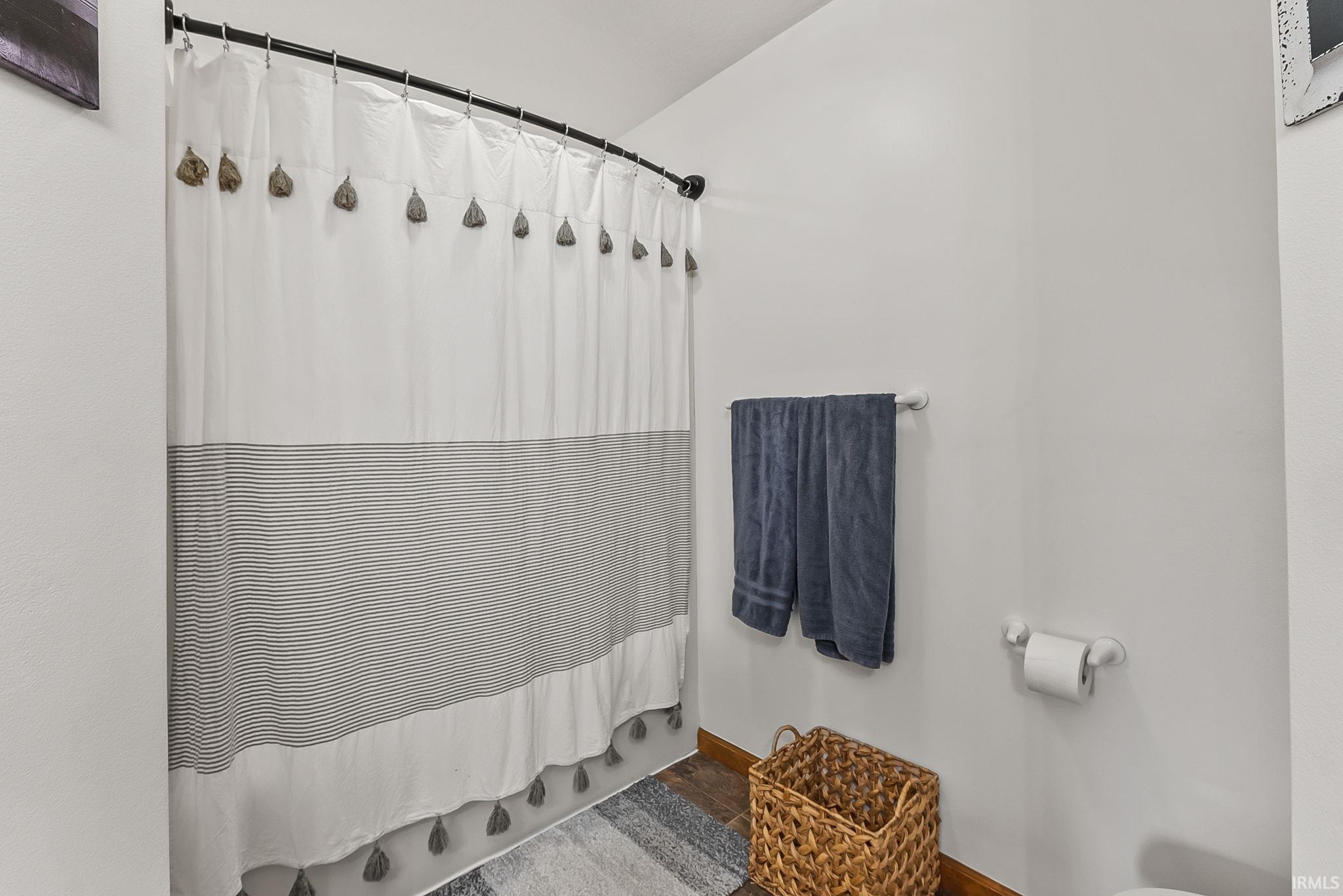 Bathroom featuring white walls and wood-finish flooring