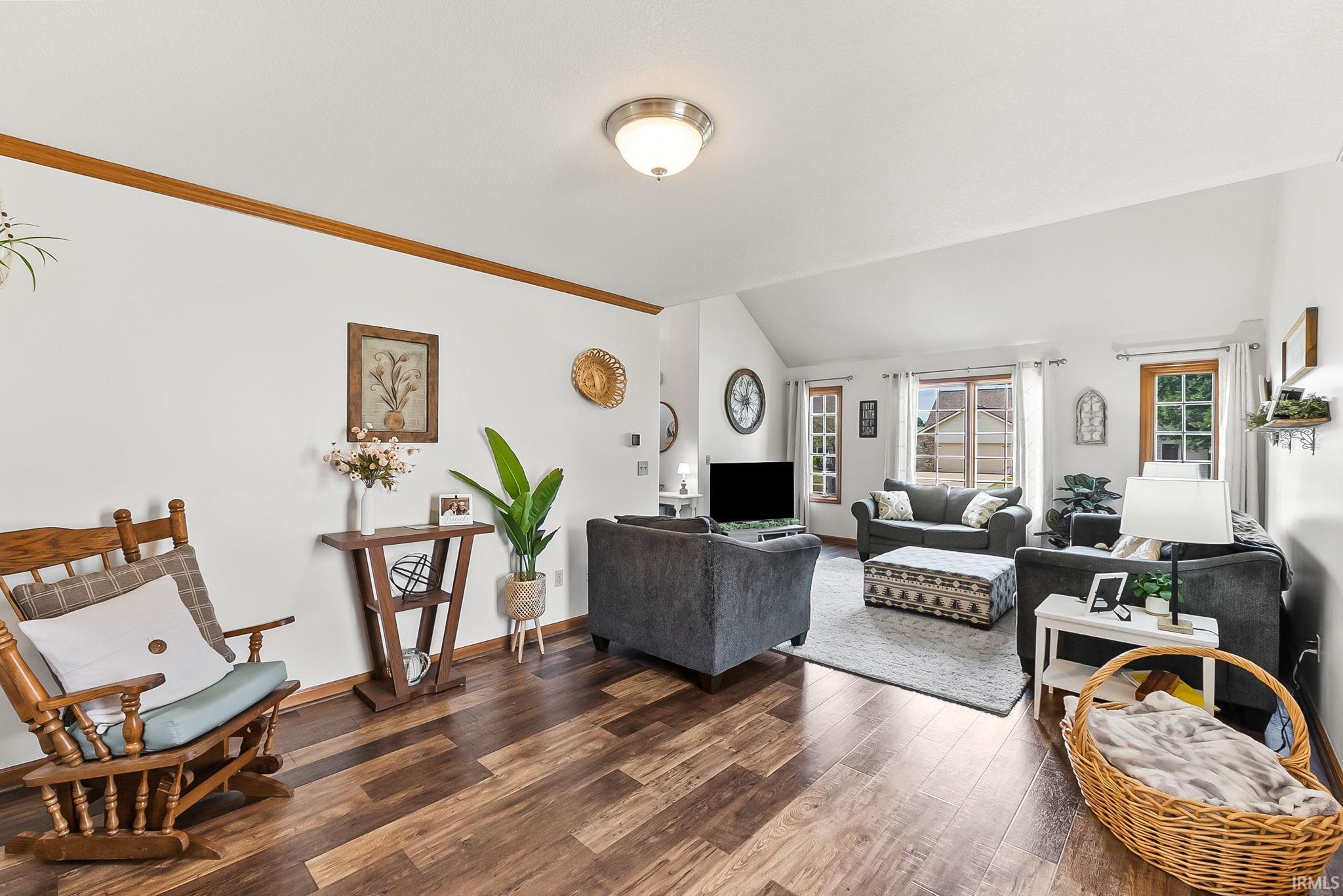 Open-concept living area featuring wood-finish flooring and white walls