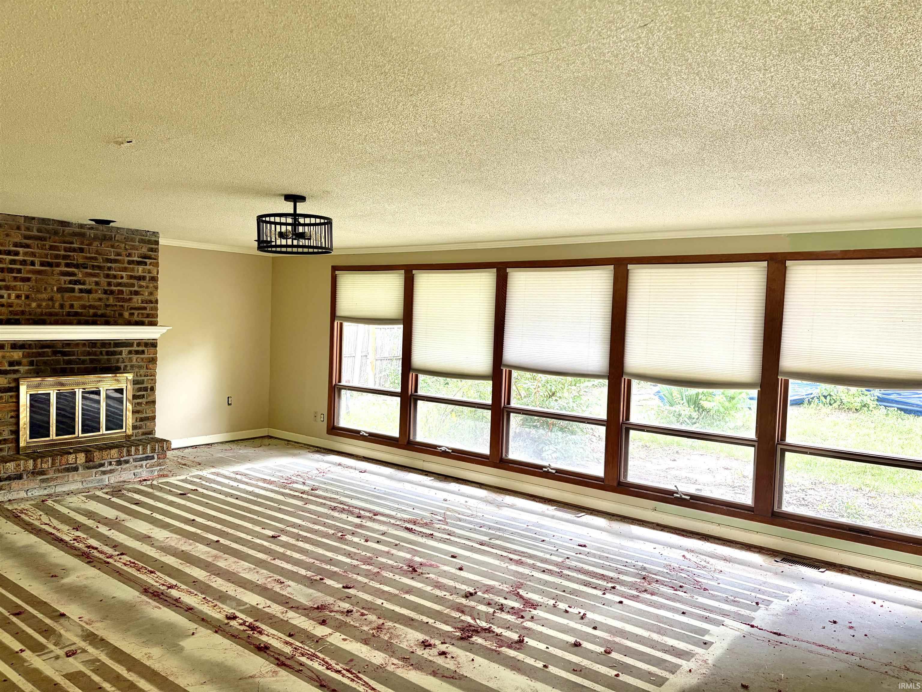 Spacious interior featuring a brick fireplace with a brass-toned insert and mantel