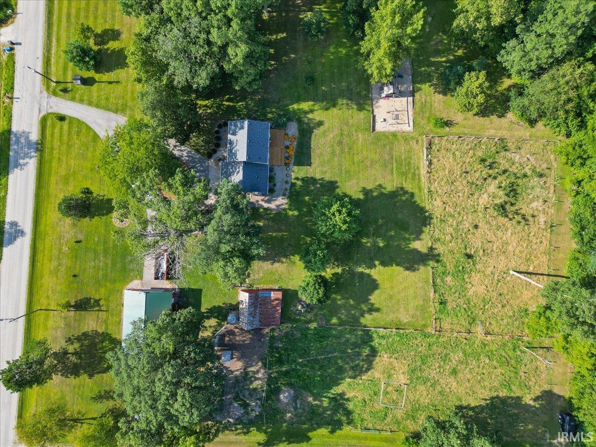 Expansive property with a residence, multiple outbuildings, and mature trees