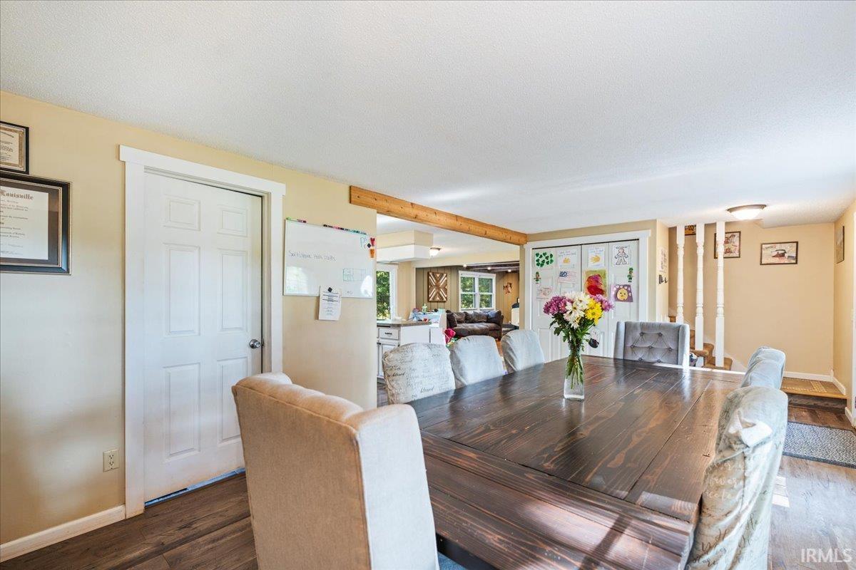 Dining area featuring wood-finish flooring and a wood beam accent