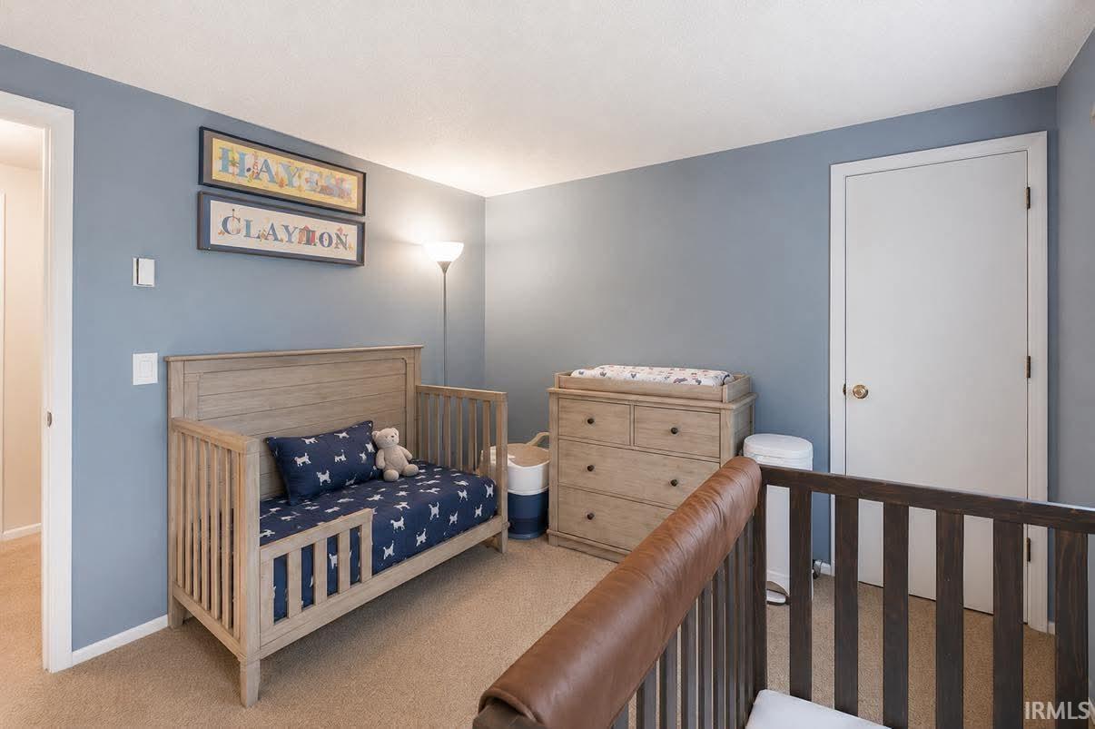 Carpeted room with light blue painted walls, a white ceiling, and white trim