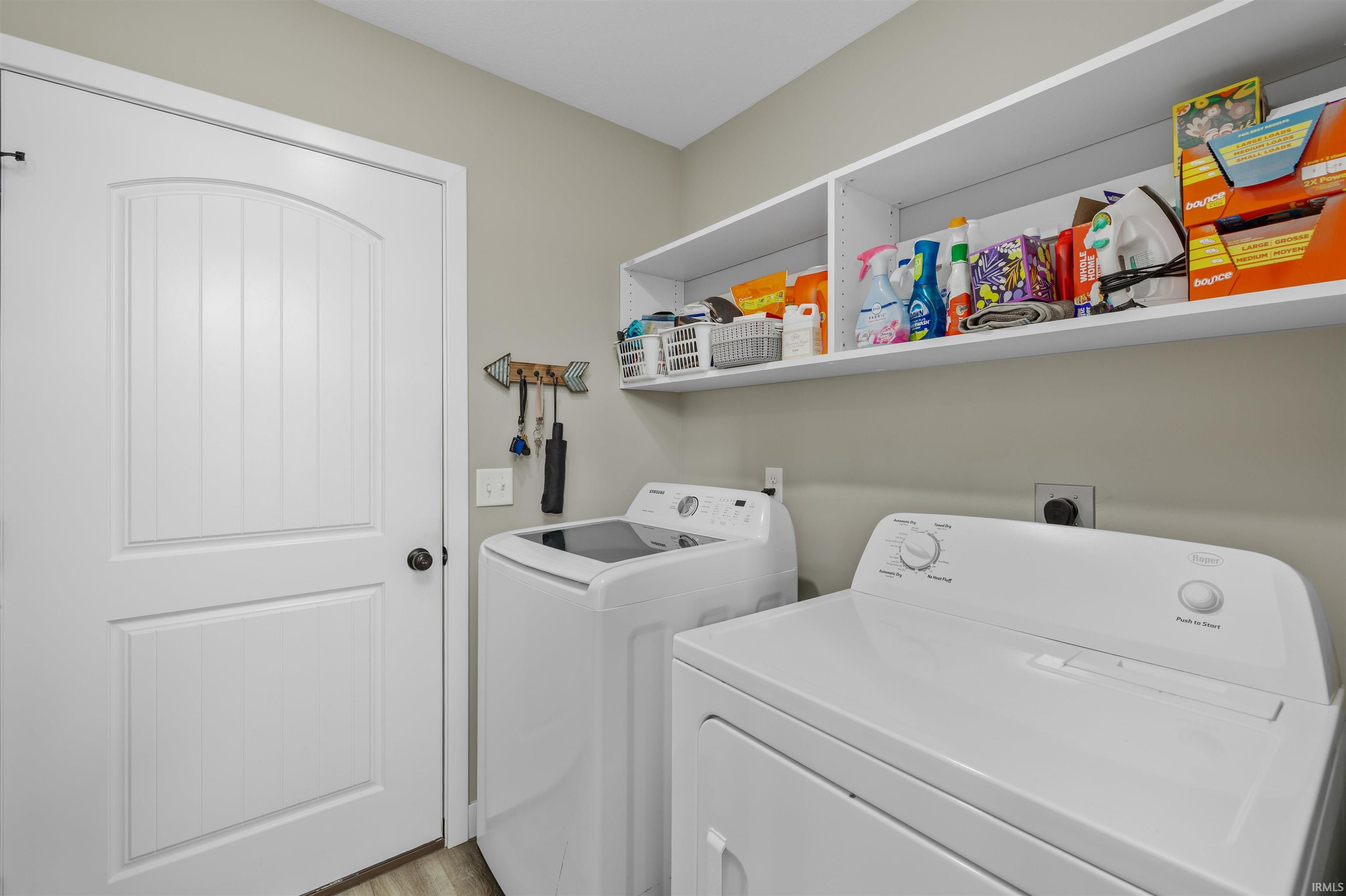 Dedicated laundry area featuring a white paneled door, built-in shelving, and a neutral wall color