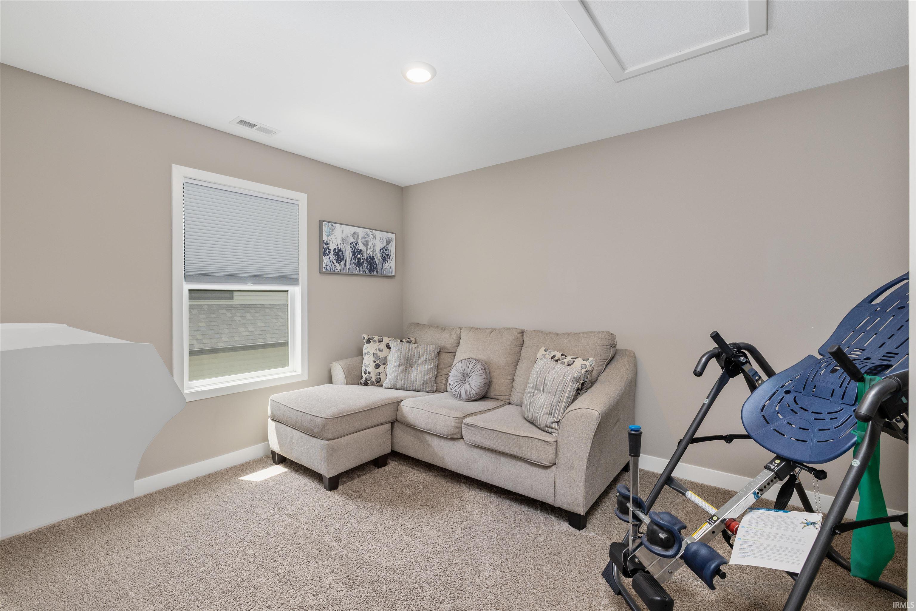 Carpeted room with a single window featuring a cellular shade and white trim
