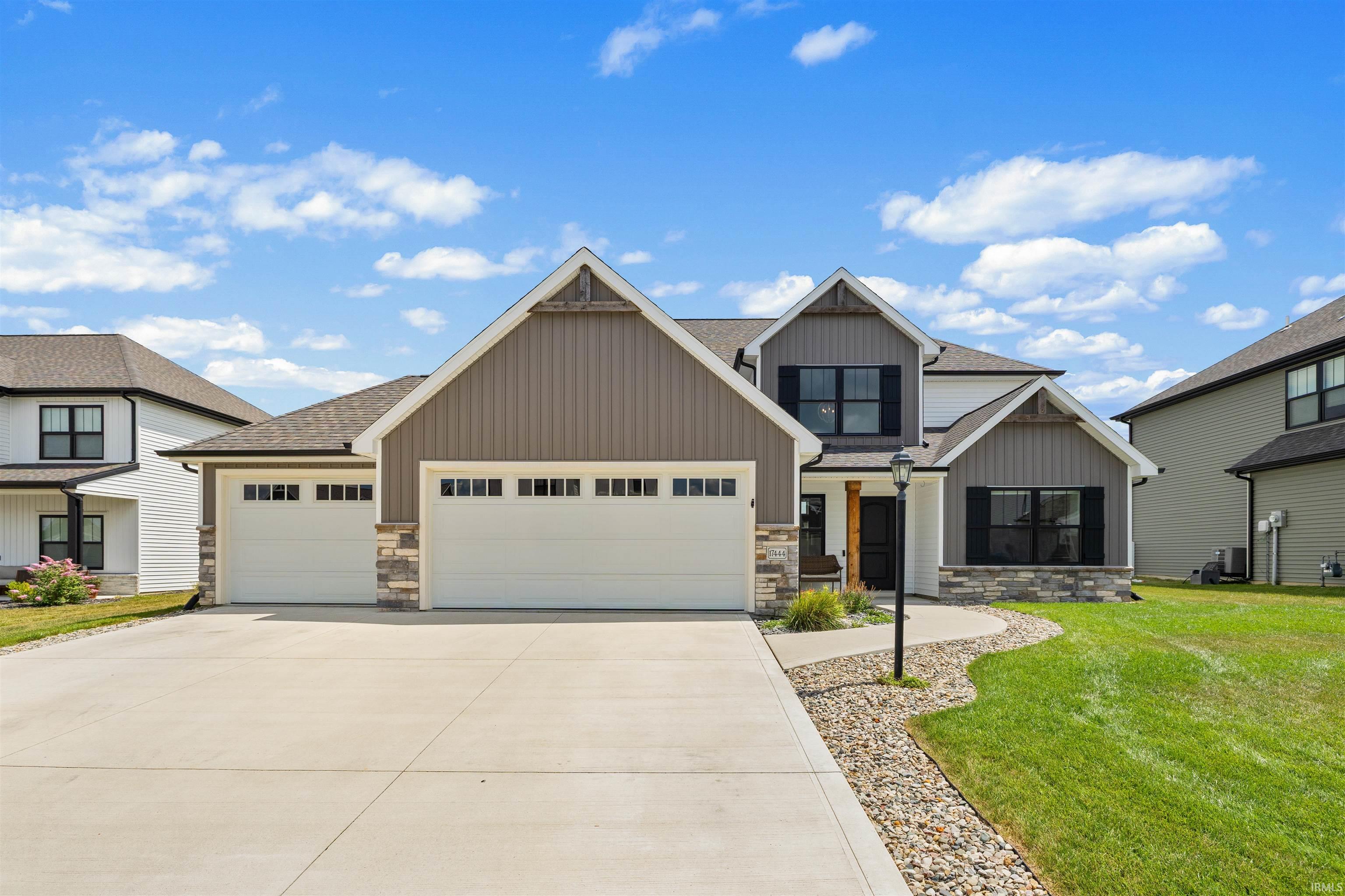 Contemporary two-story residence featuring a combination of horizontal and vertical siding with stone accents