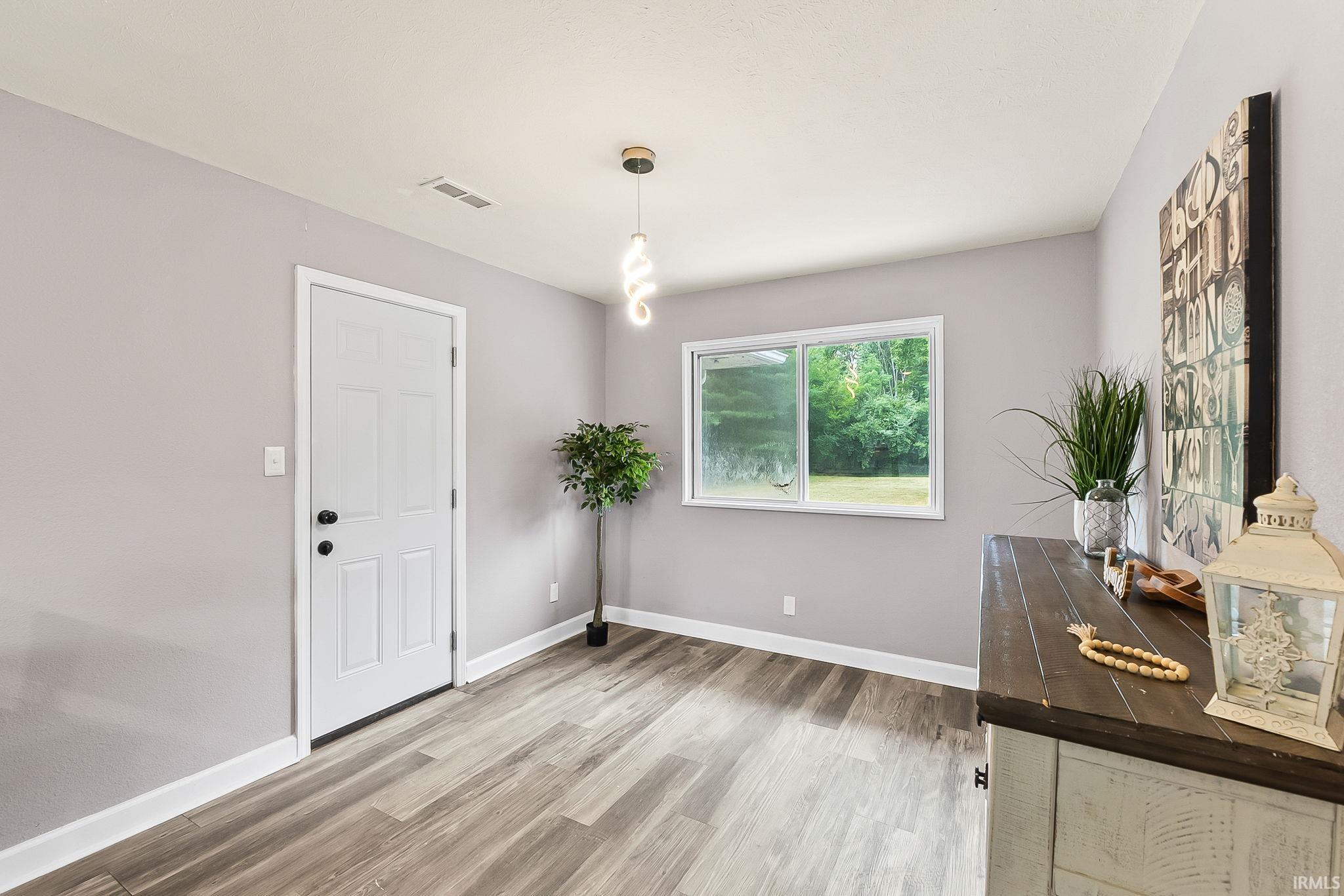 Interior room with wood-finish flooring, light grey walls, and white trim