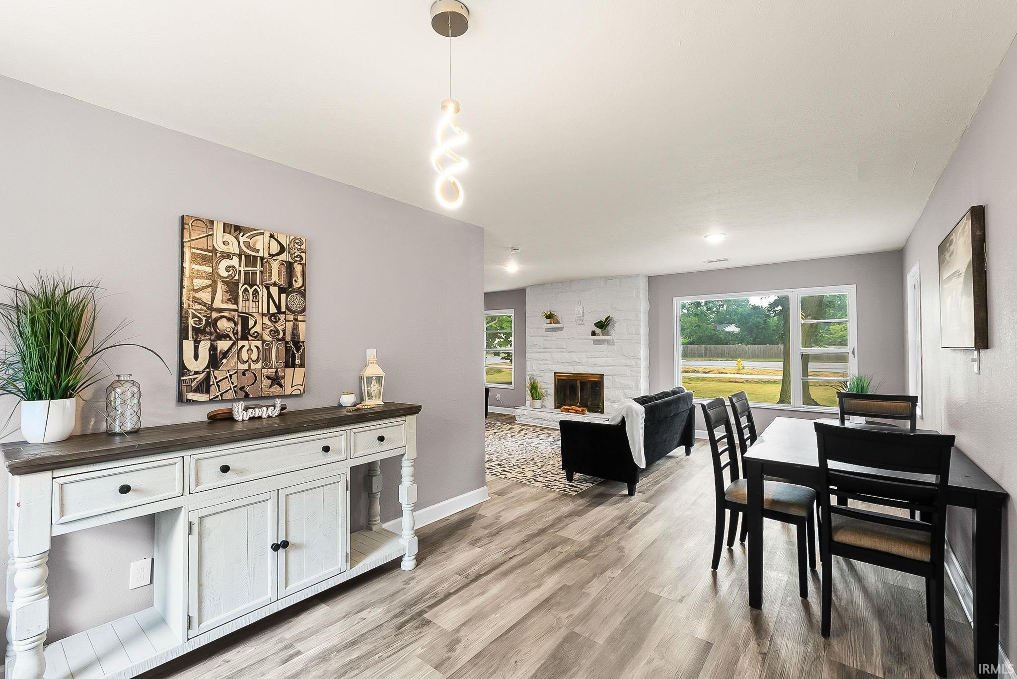 Dining area featuring wood-finish flooring and a contemporary linear pendant light fixture