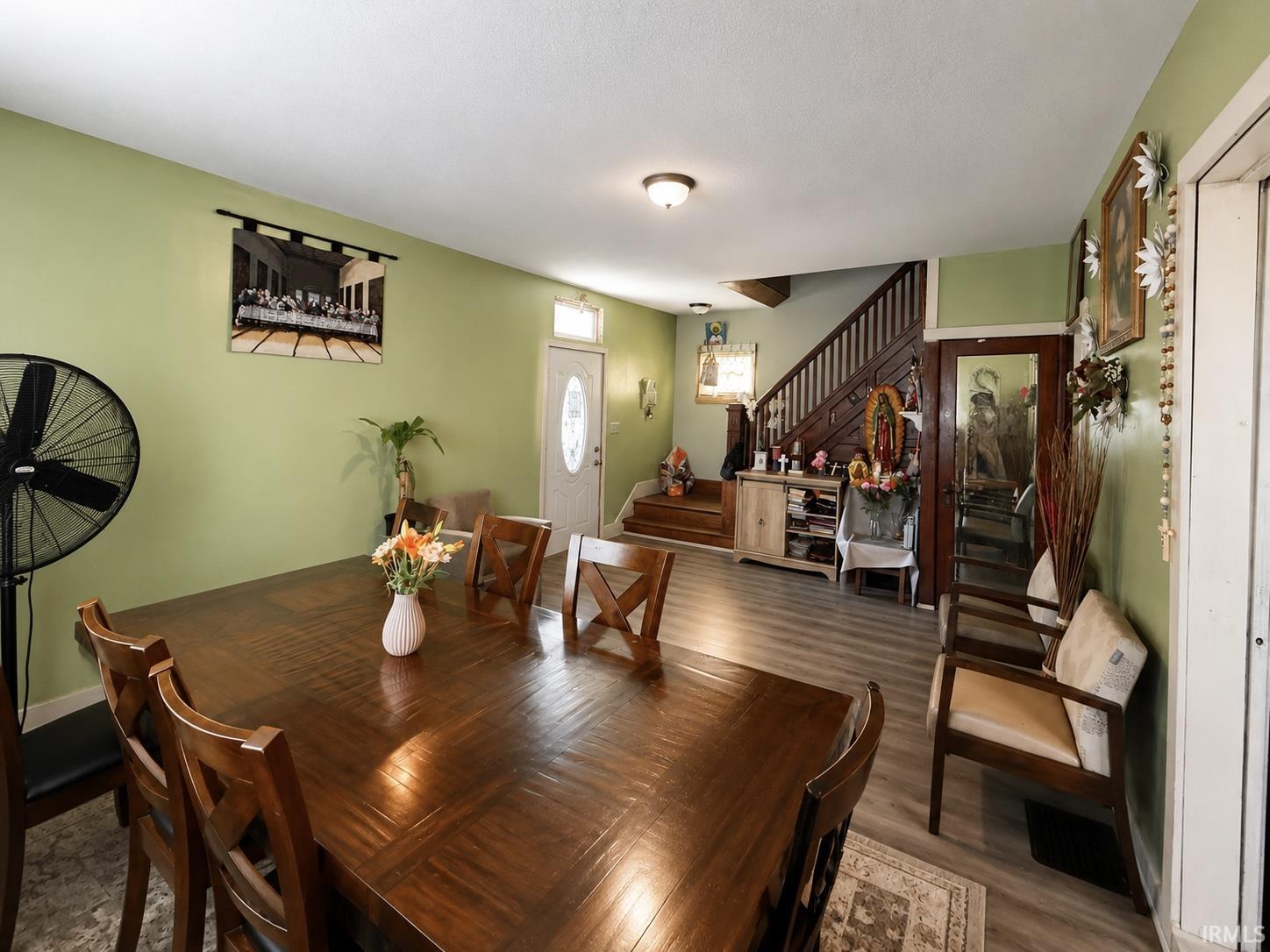 Spacious interior featuring light green walls and wood-finish flooring