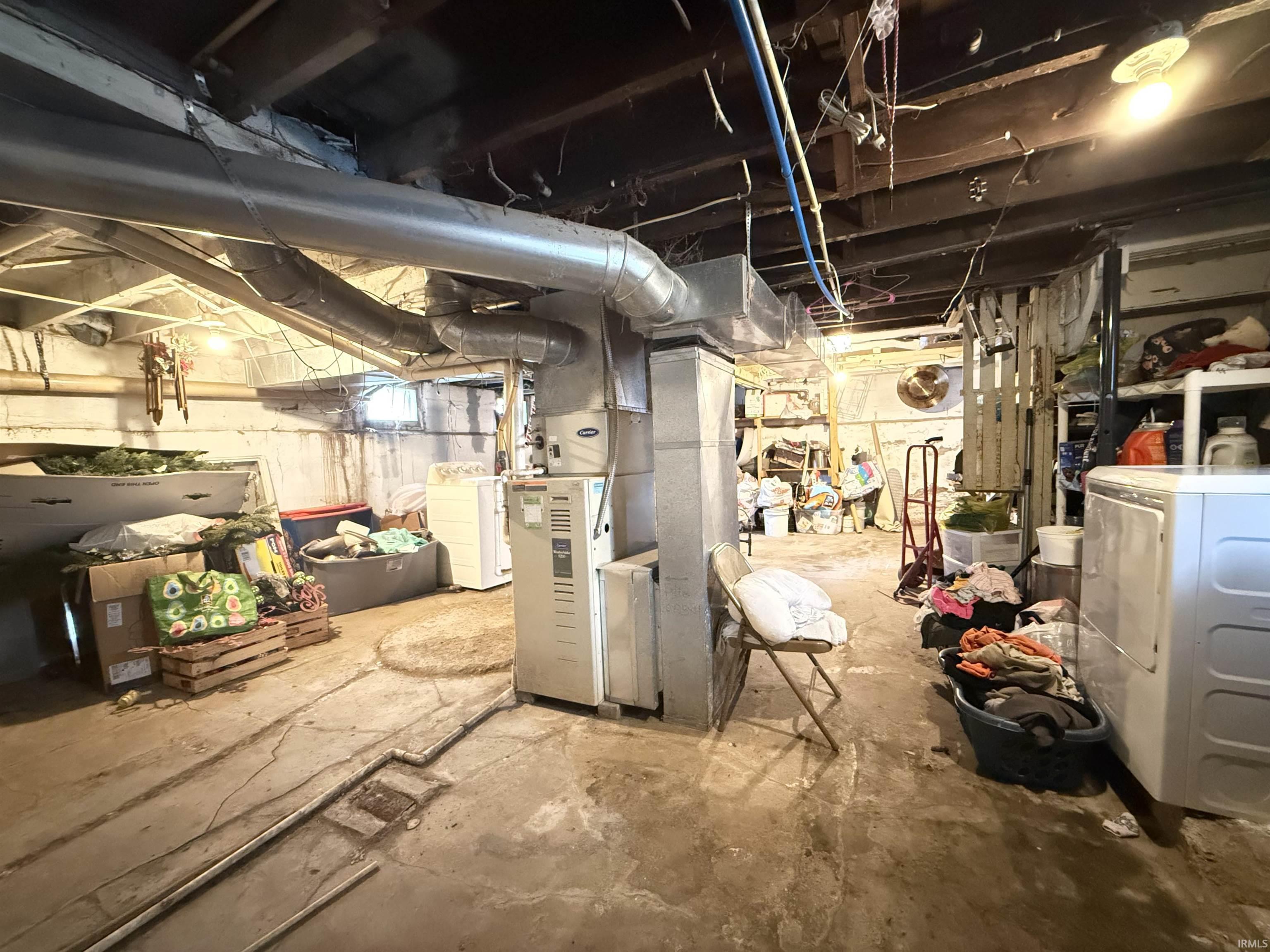 Unfinished basement featuring exposed joists, ductwork, and concrete flooring