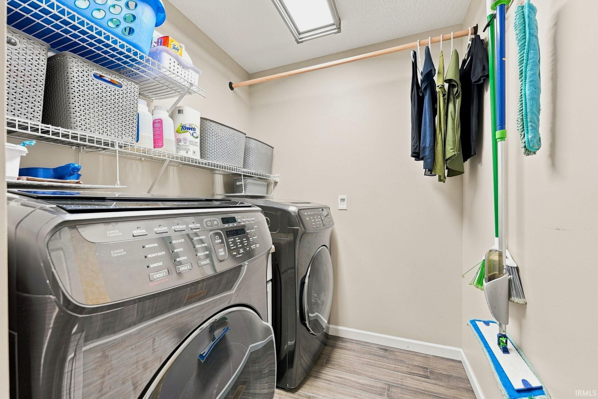 Dedicated laundry area featuring wood-finish flooring and neutral wall tones
