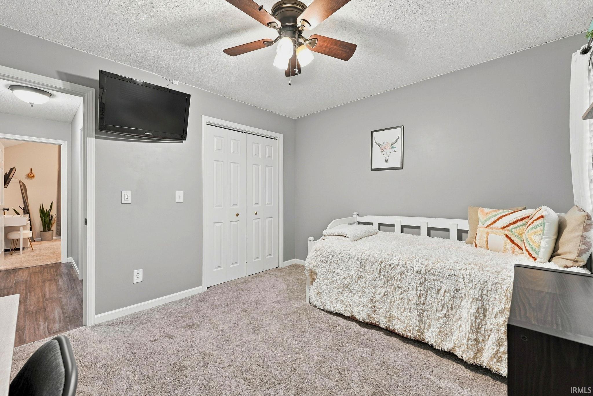 Carpeted room with light gray walls and a ceiling fan