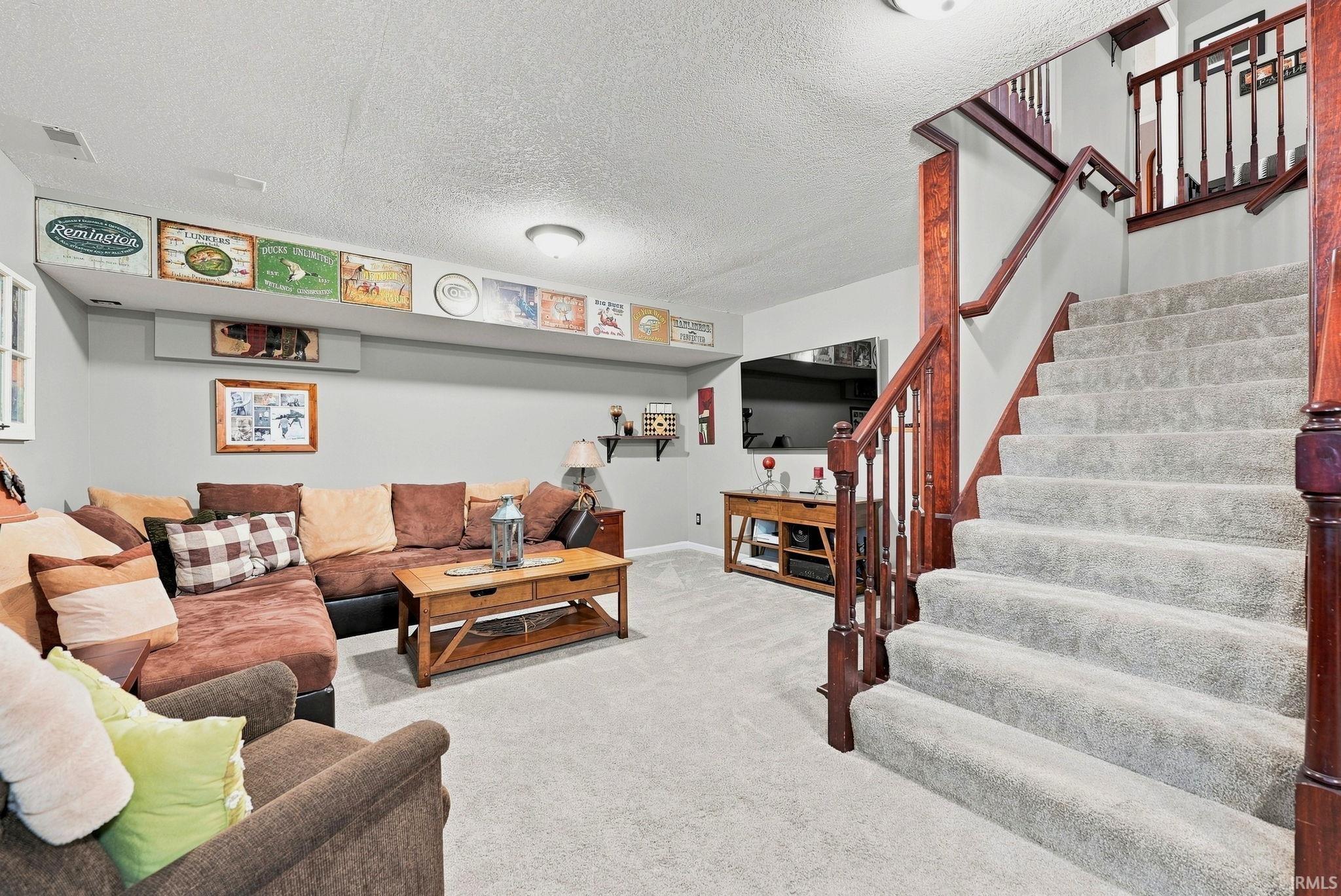 Carpeted stairs with wood newel posts and railings