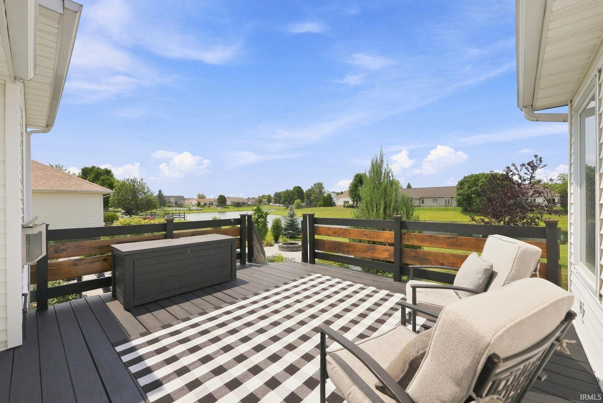 Spacious outdoor deck featuring dark composite decking and a modern black and wood-tone railing