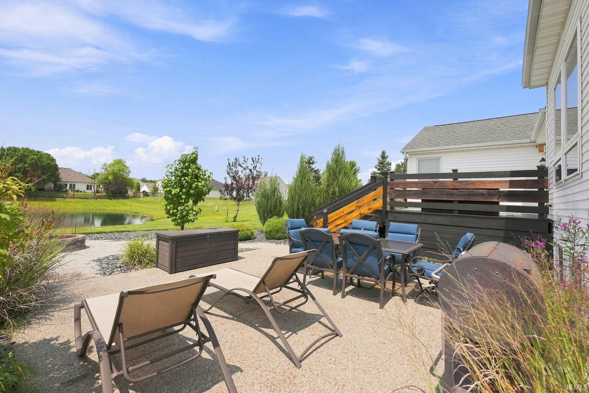 Expansive outdoor patio area featuring a textured concrete surface and a gravel fire pit area