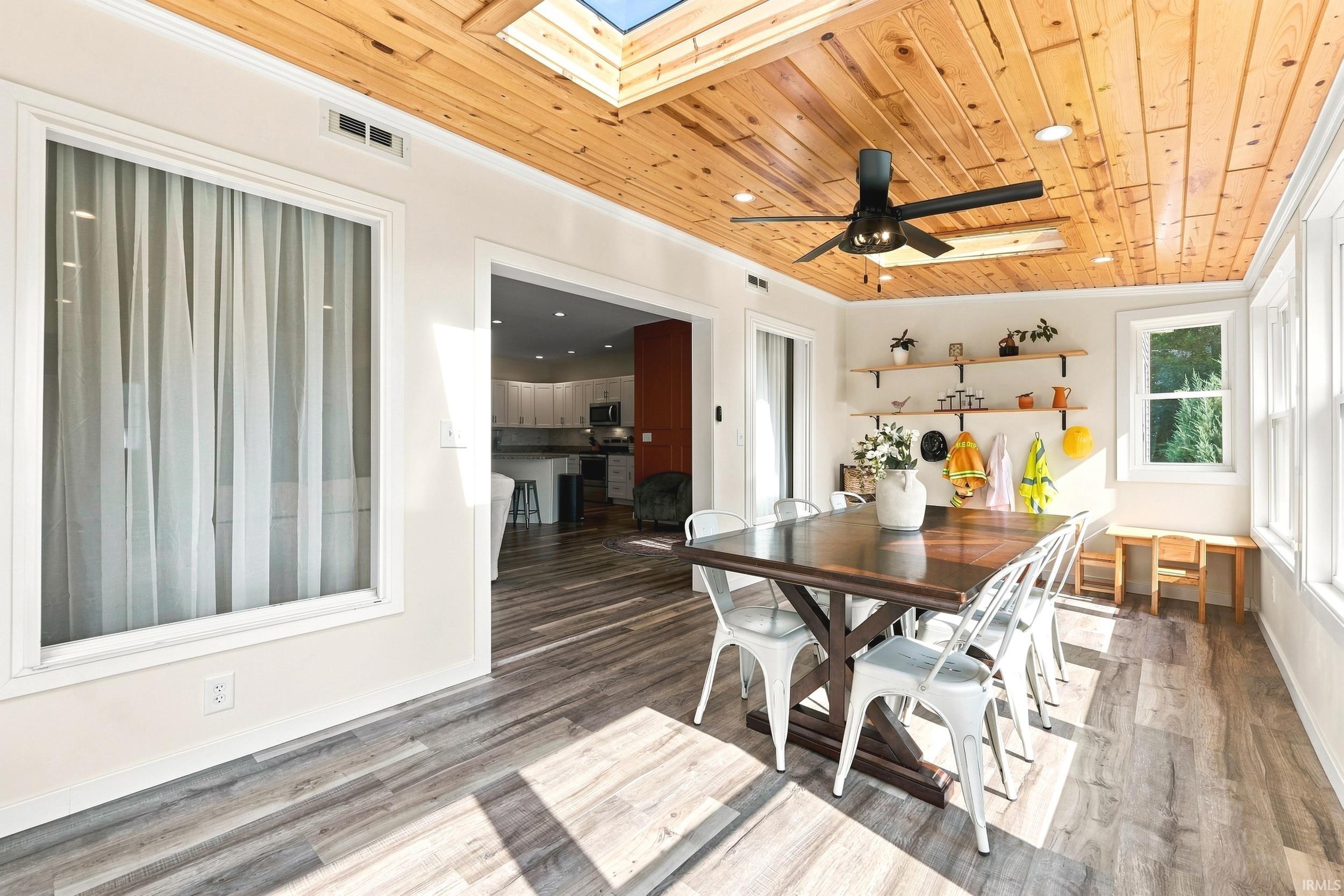 Dining area featuring wood-finish flooring, a planked wood ceiling with recessed lighting and a ceiling fan, and multiple windows