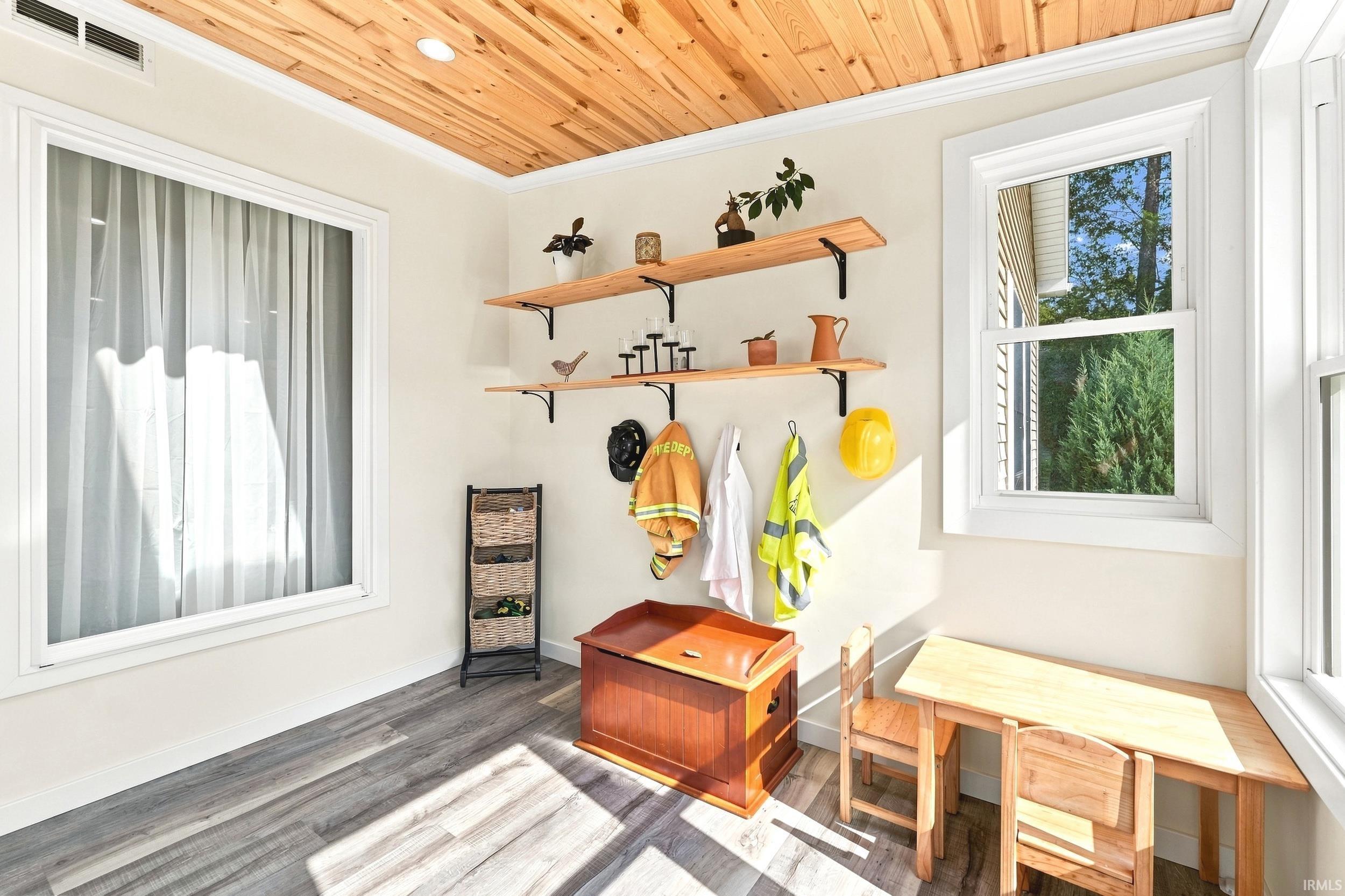 Room featuring a natural wood plank ceiling with recessed lighting, light-toned walls, and wood-finish flooring