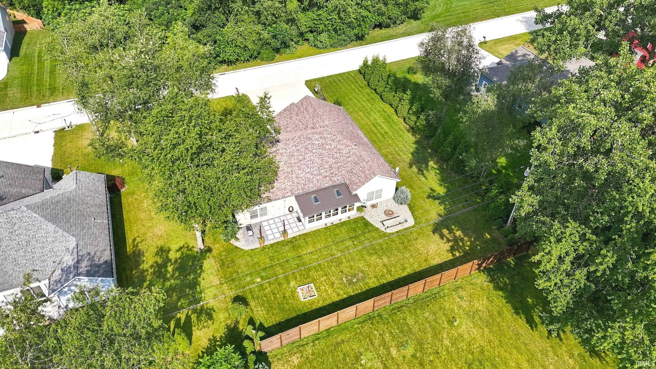 Rear exterior featuring a sunroom, patio area, and stone fire pit