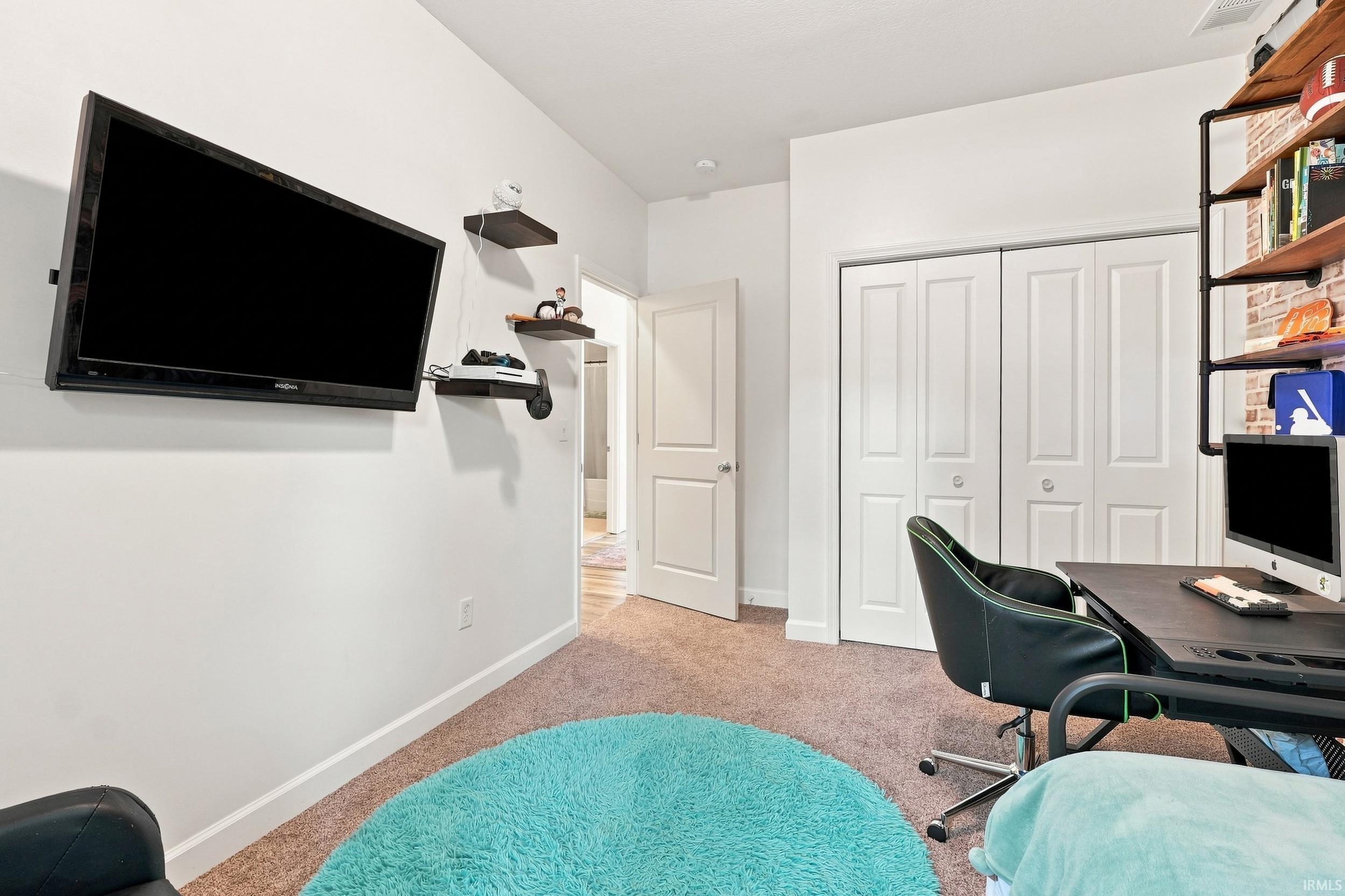 Neutral wall color with a wall-mounted television and built-in shelving