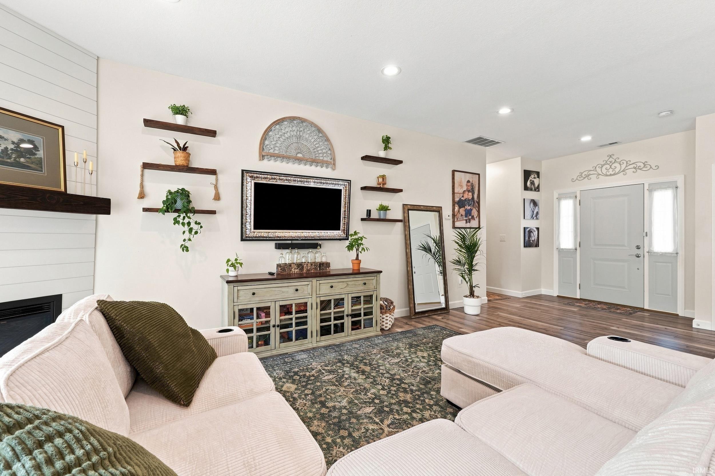 Living area featuring wood-finish flooring and recessed lighting