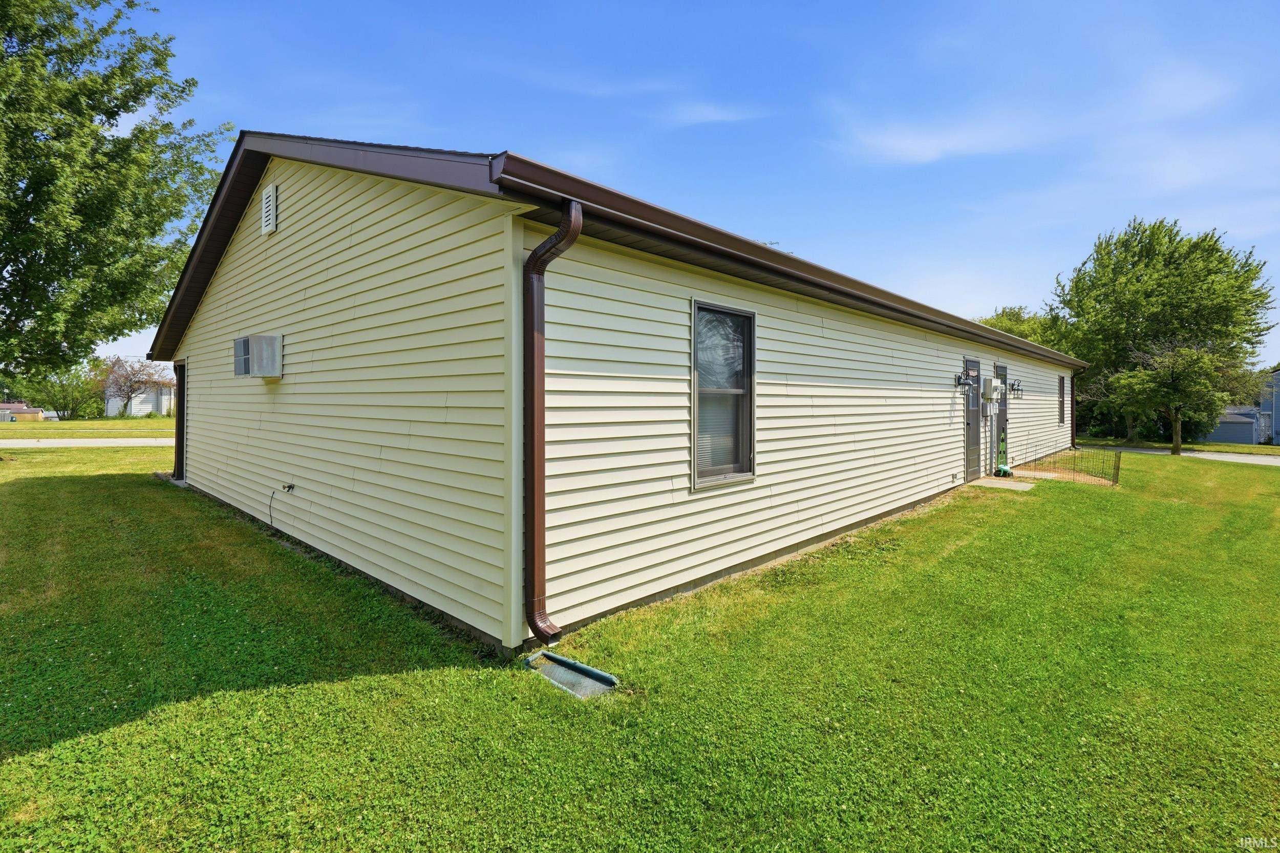 Exterior featuring light-colored horizontal siding and dark brown gutters