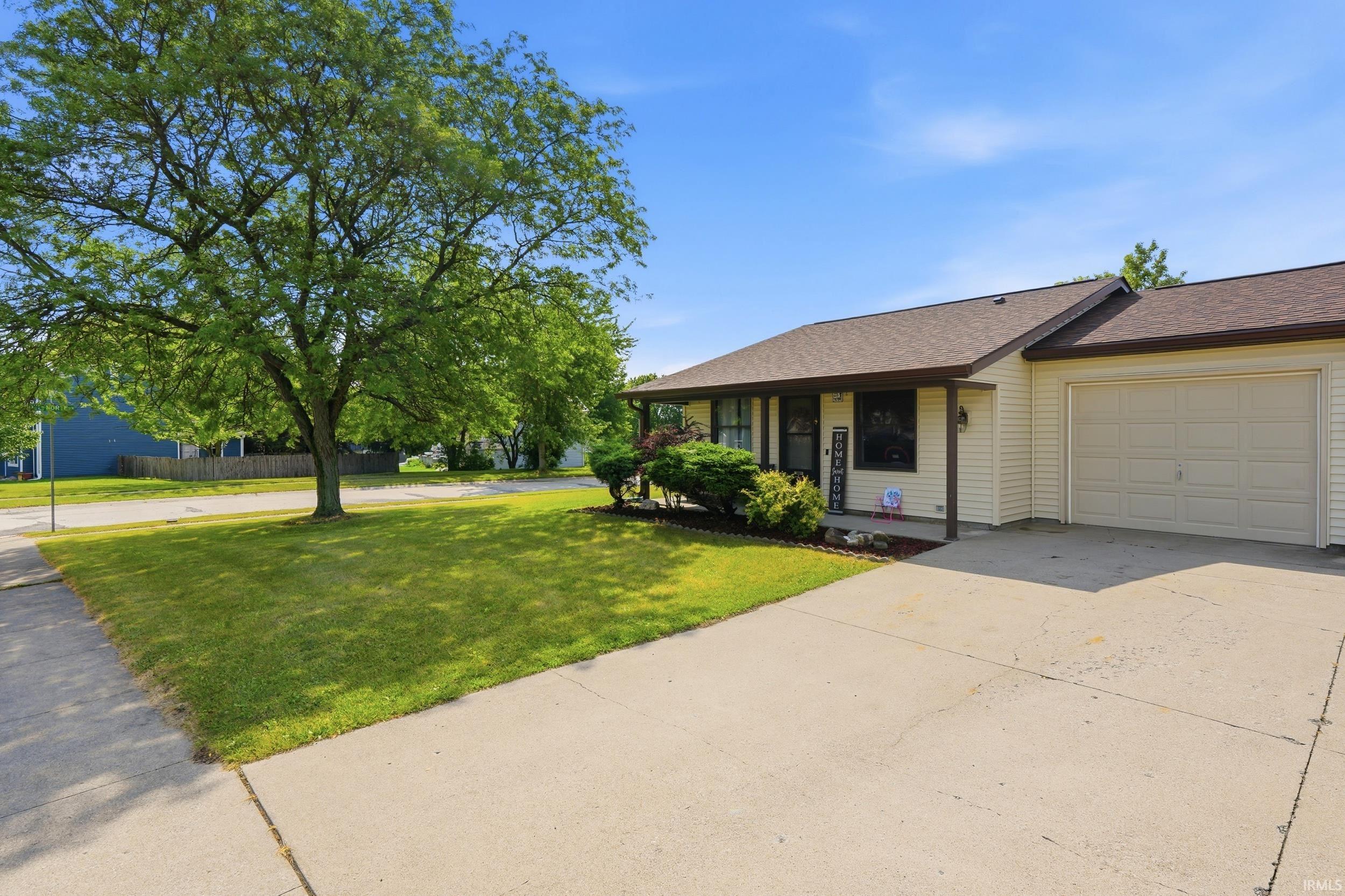 Ranch-style exterior with beige siding and a dark brown shingle roof