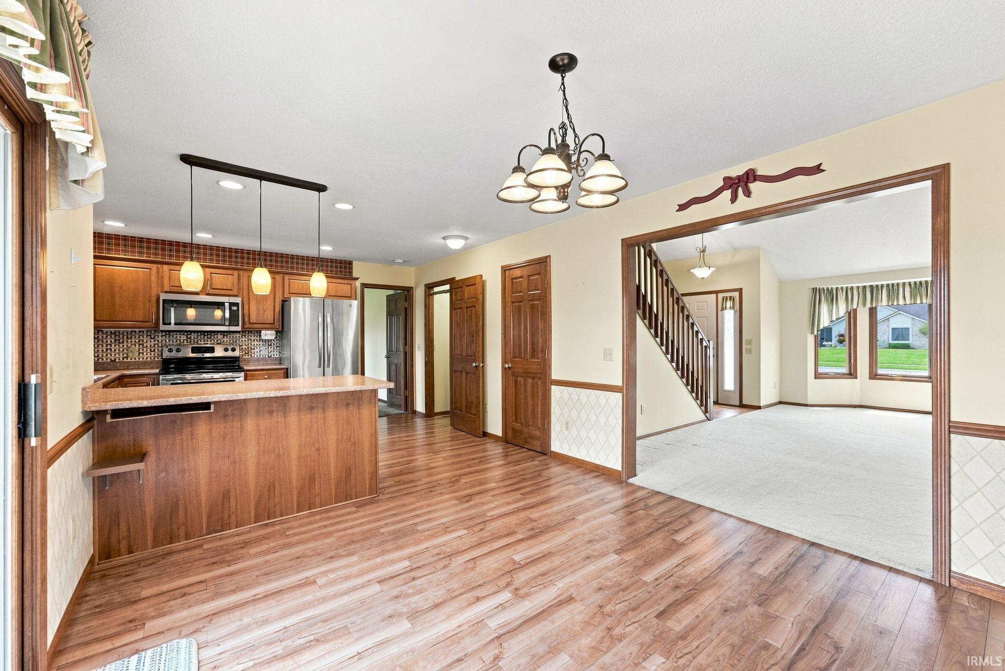 Kitchen with wood-finish flooring, wood cabinetry, and stainless steel appliances