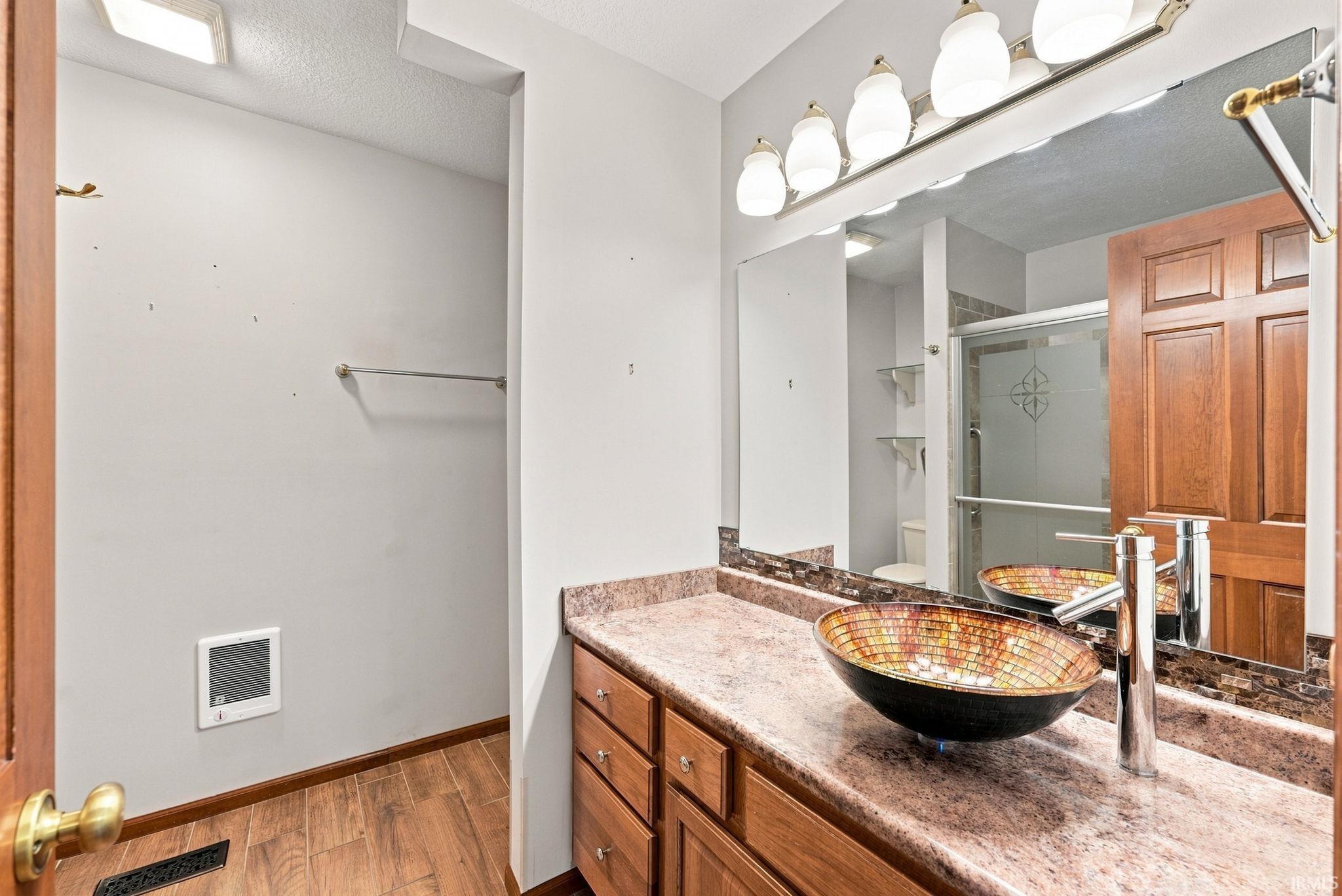 Bathroom vanity with a vessel sink, a full-width mirror, and a five-light fixture