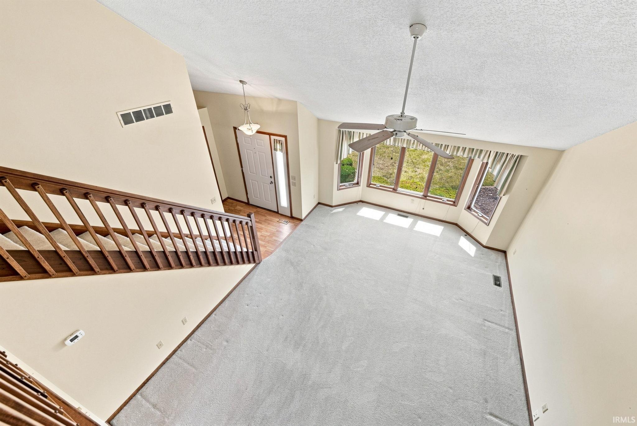 Two-story entry foyer with wood-finish flooring