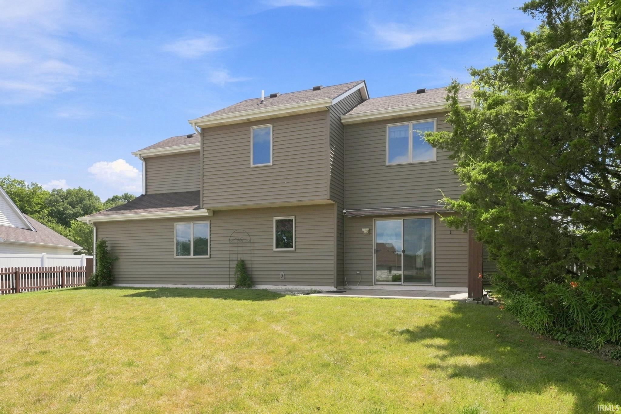 Rear exterior with siding, multiple windows, and a sliding glass door