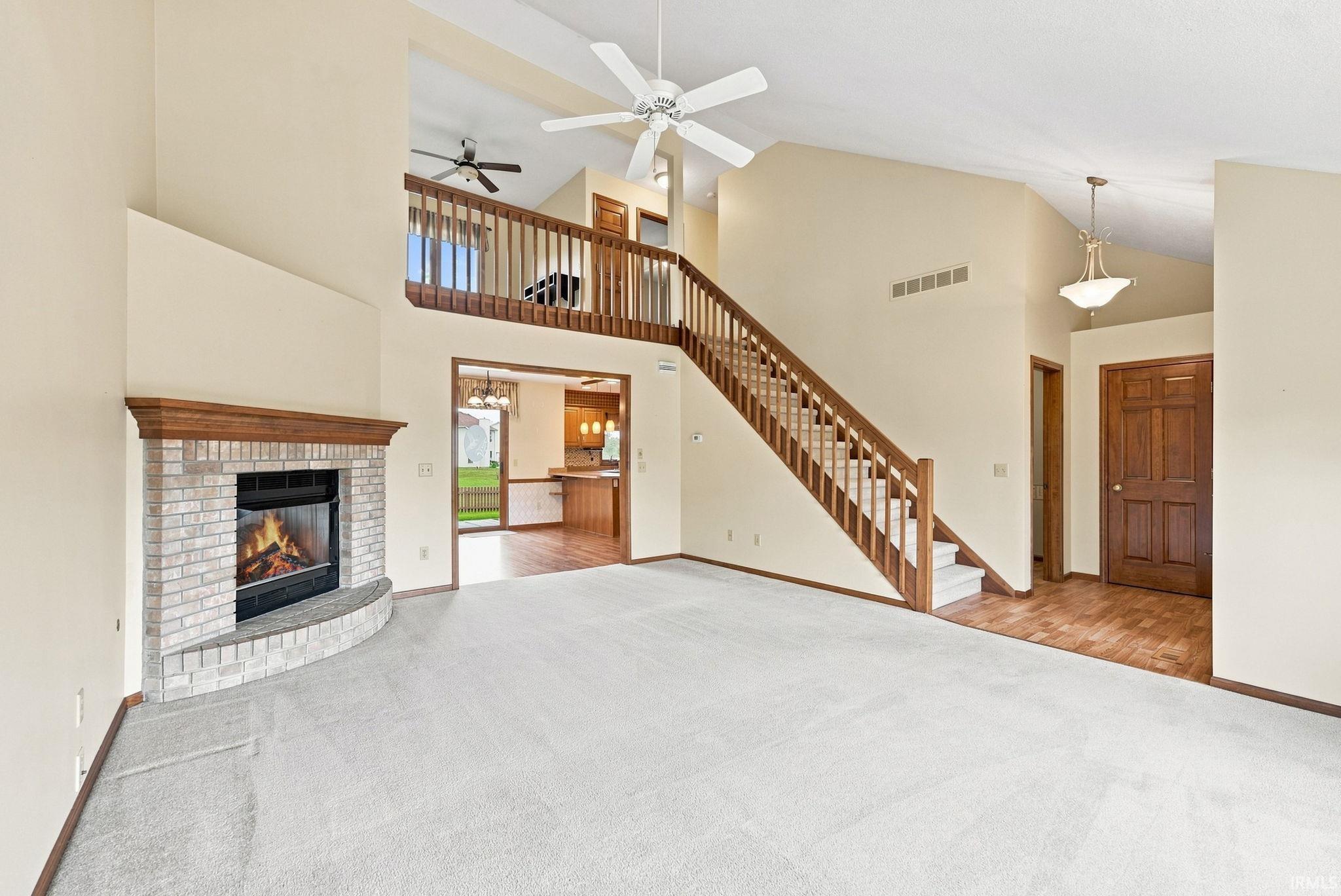 Living area featuring a floor-to-ceiling fireplace with a light brick surround and wood mantel
