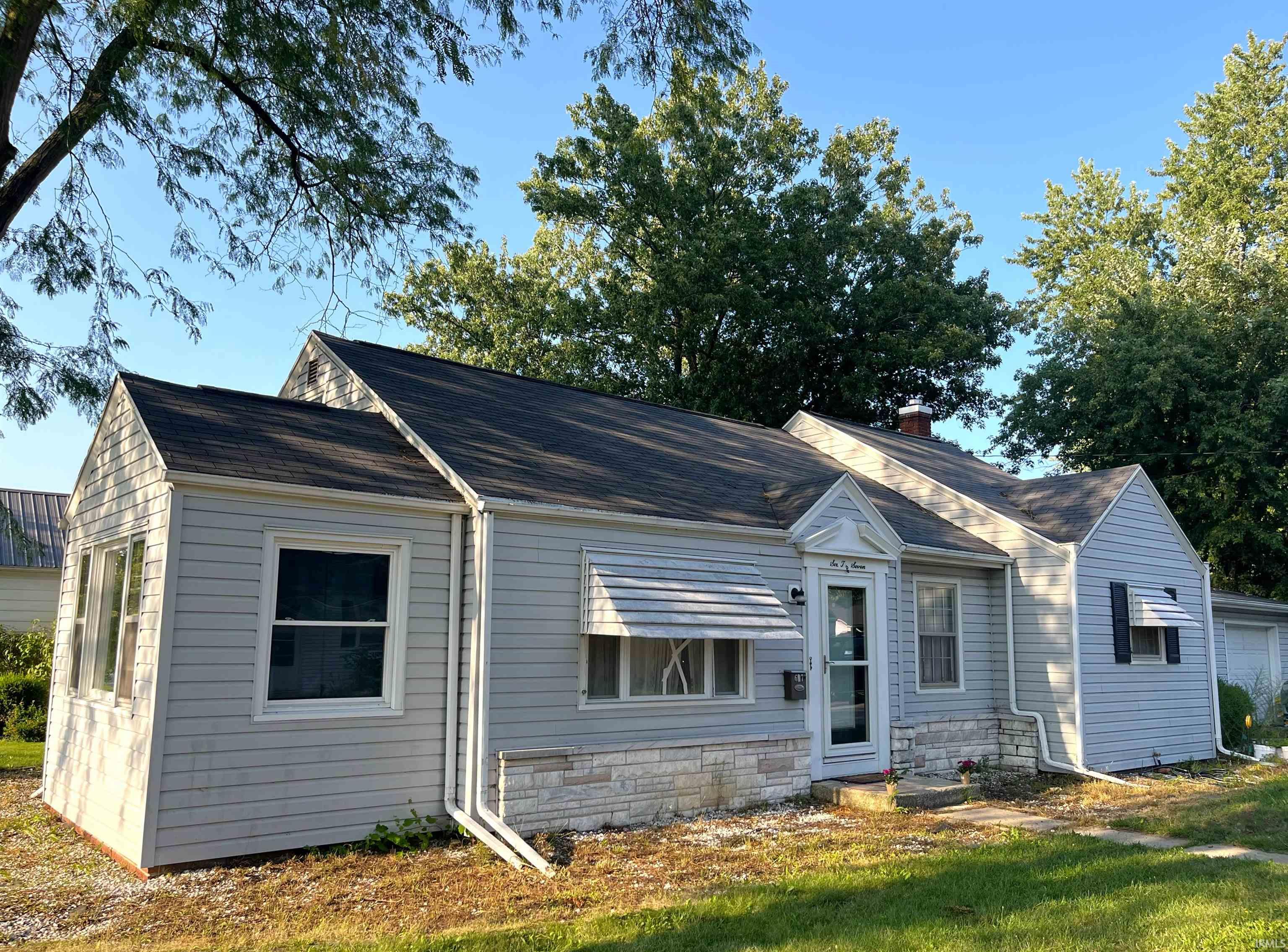 Light-colored horizontal siding exterior with a dark shingle roof