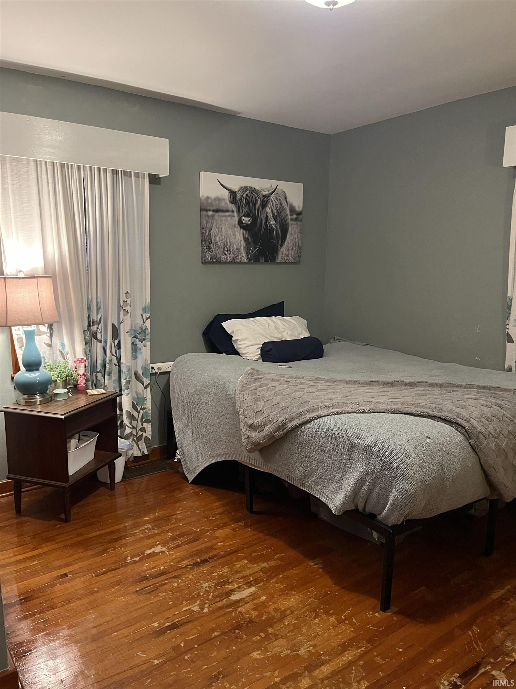 Room with hardwood flooring and light green walls