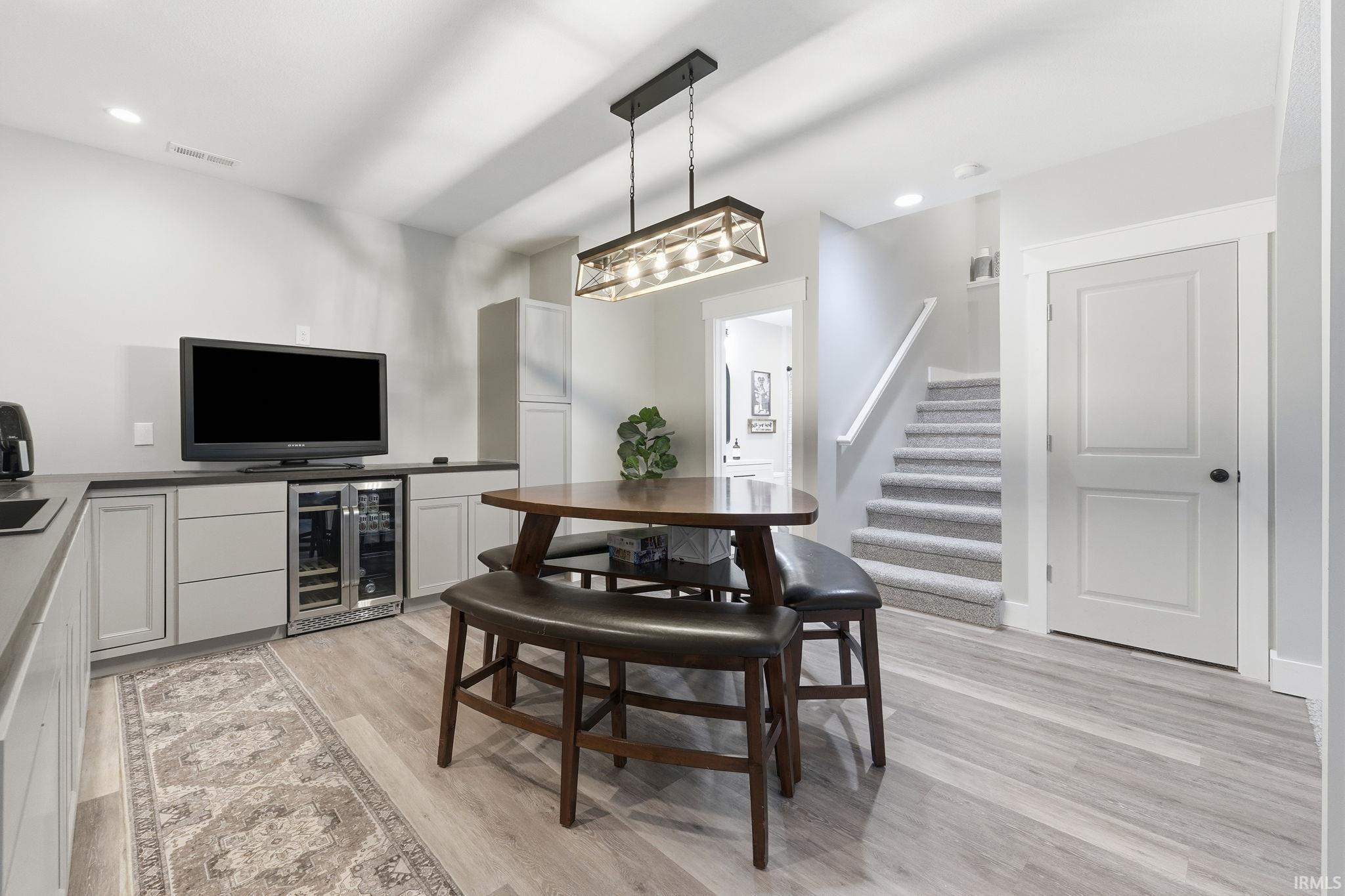 Lower-level entertainment space featuring light wood-finish flooring and recessed lighting