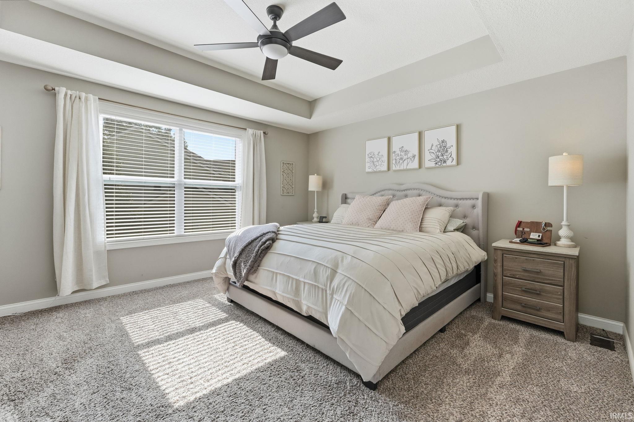 Bedroom featuring a tray ceiling, recessed lighting, ceiling fan, and carpeted flooring