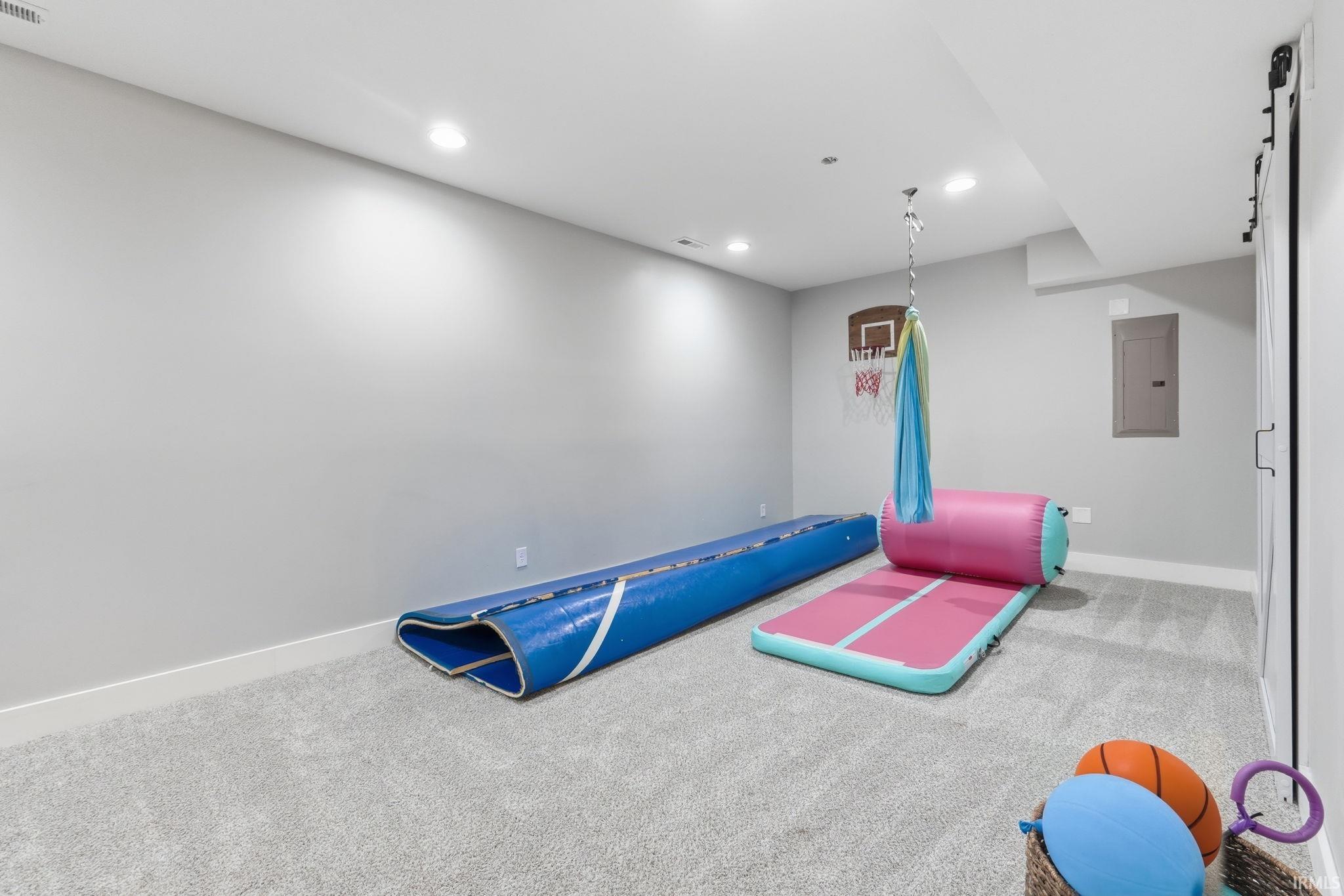 Spacious room featuring light gray walls, recessed lighting, and soft gray carpeting