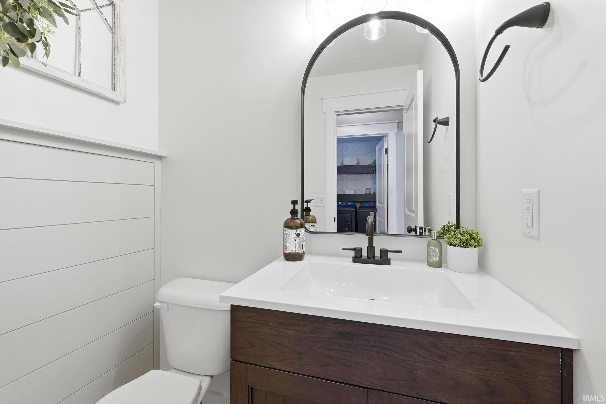 Bathroom featuring a dark wood-finish vanity with a white countertop and integrated sink