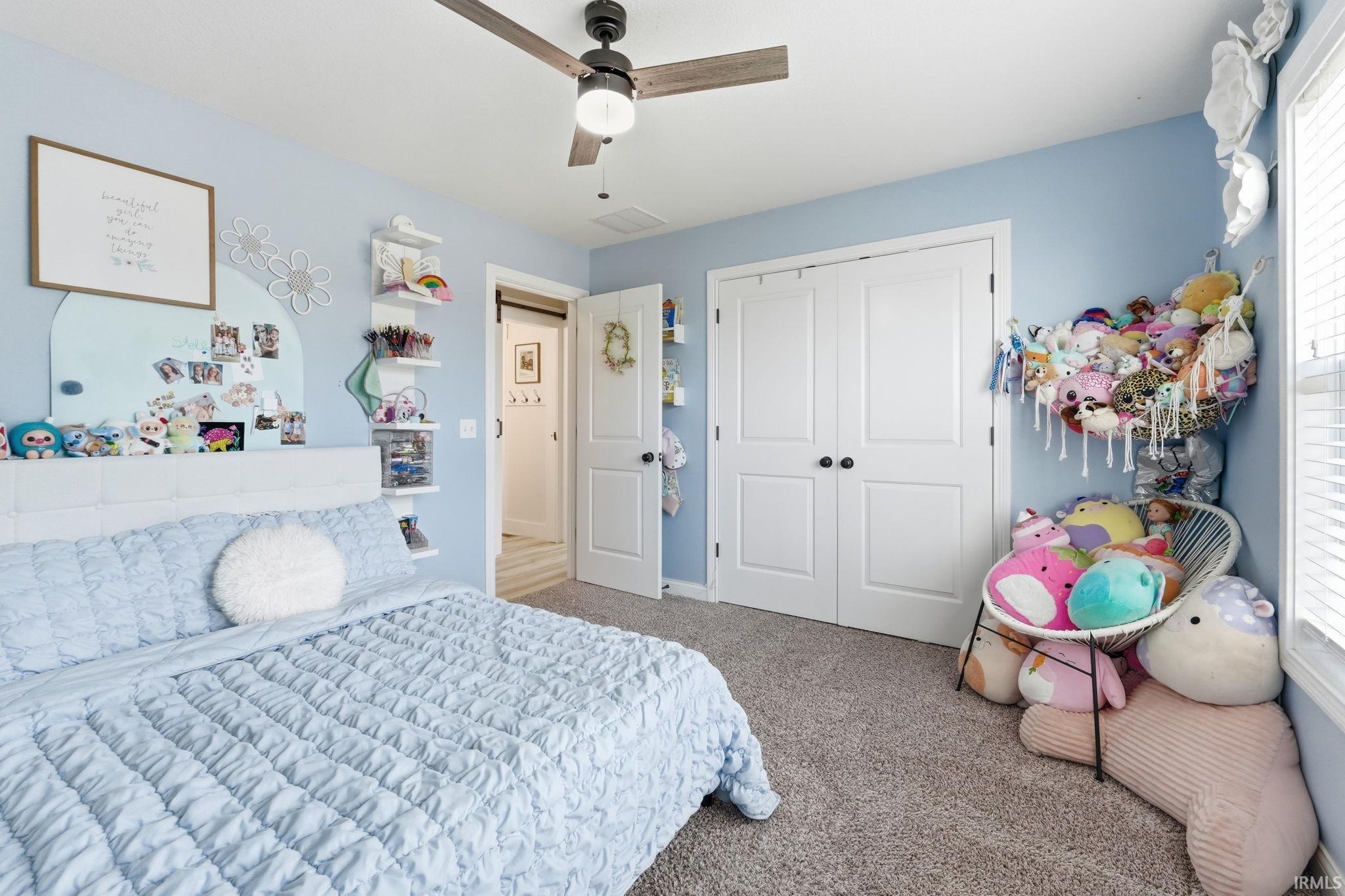 Spacious room with light blue walls and neutral carpet flooring