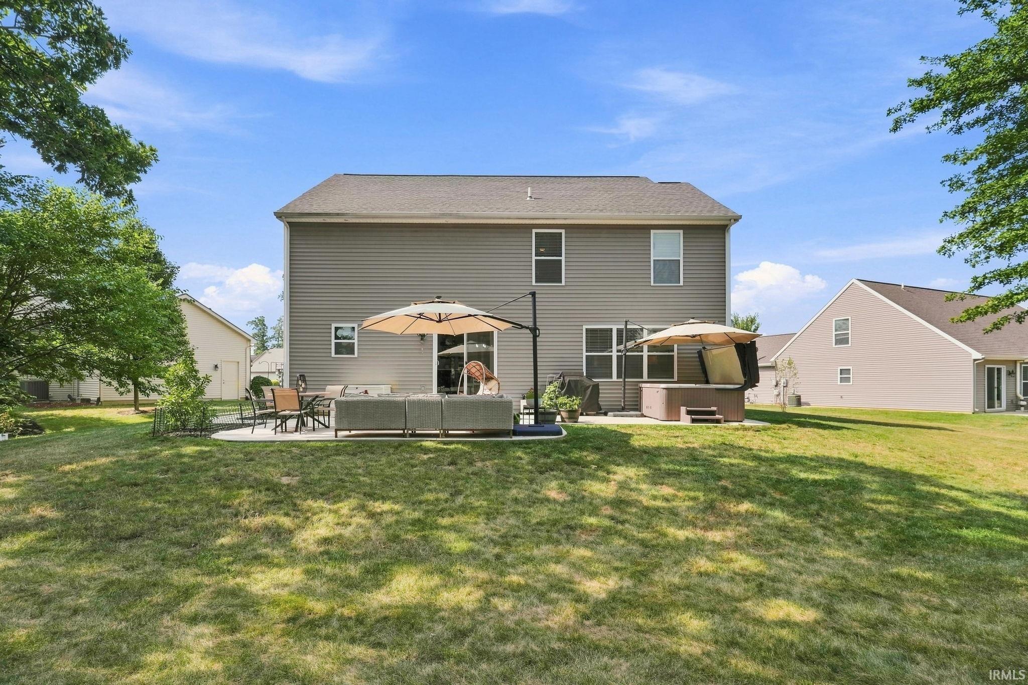 Rear elevation featuring a gray vinyl siding exterior and a gabled roof