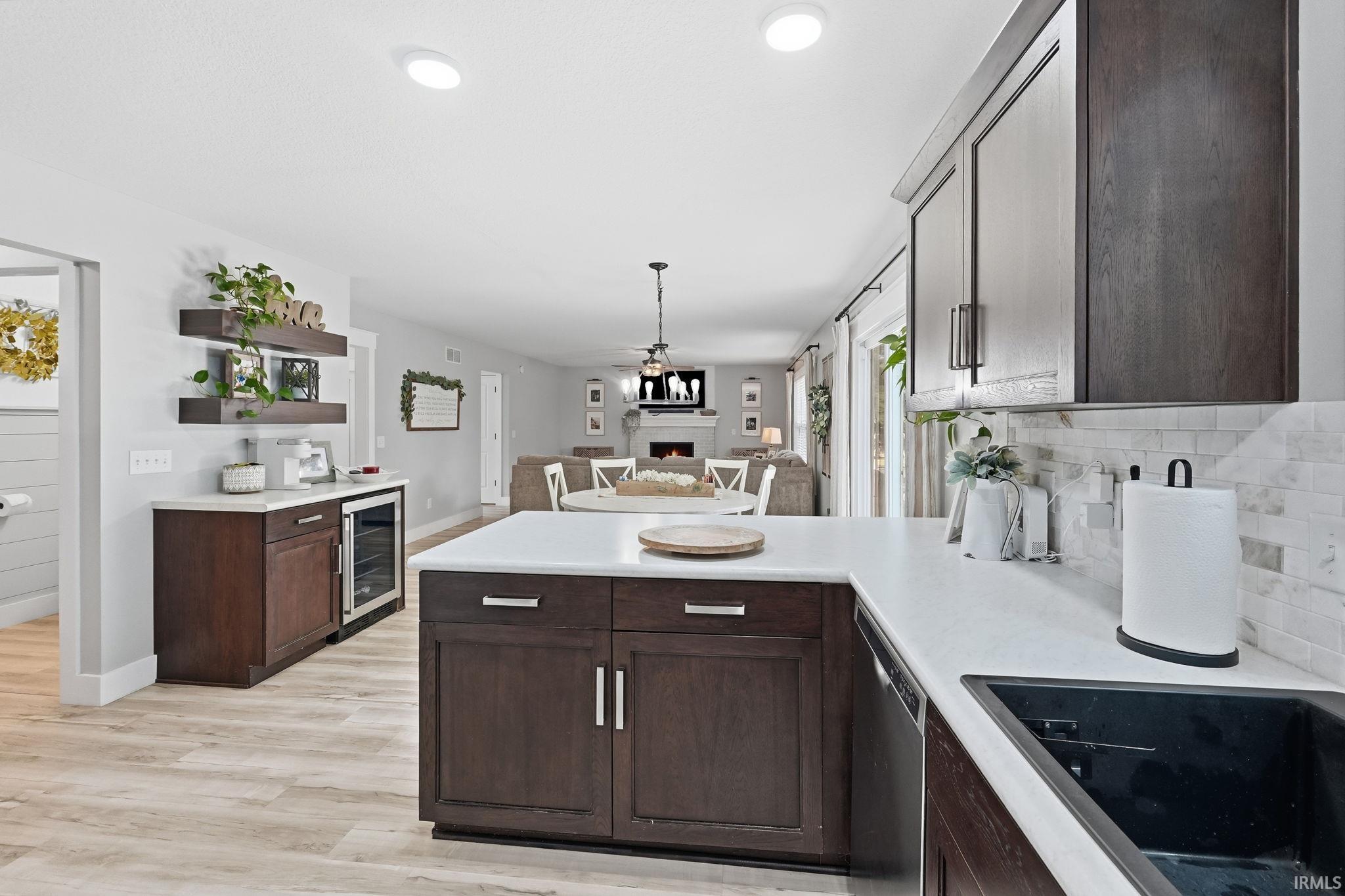 Kitchen featuring dark wood cabinetry, light countertops, and a subway tile backsplash