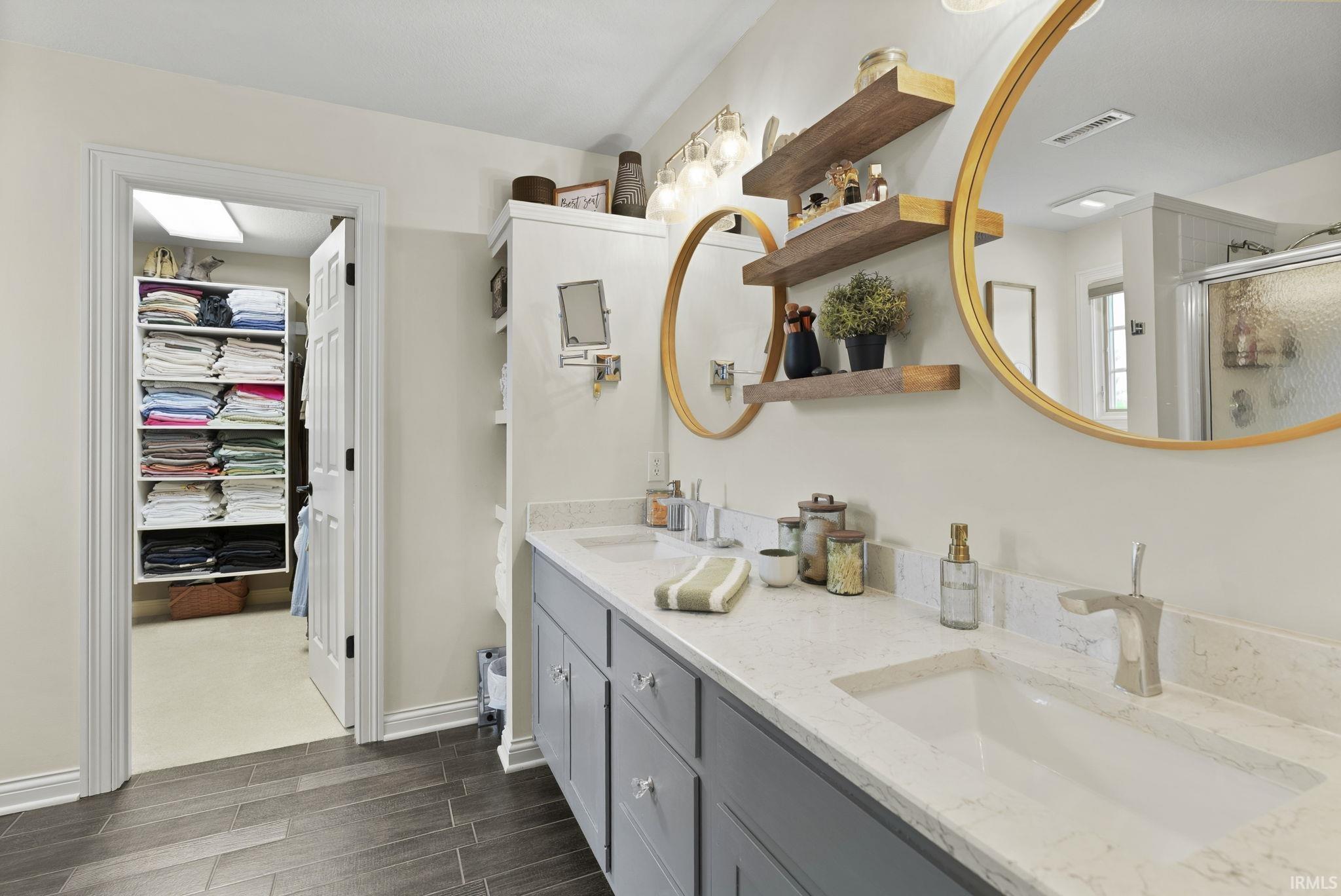 Dual vanity with built-in cabinetry, under-mount sinks, and light-toned countertops