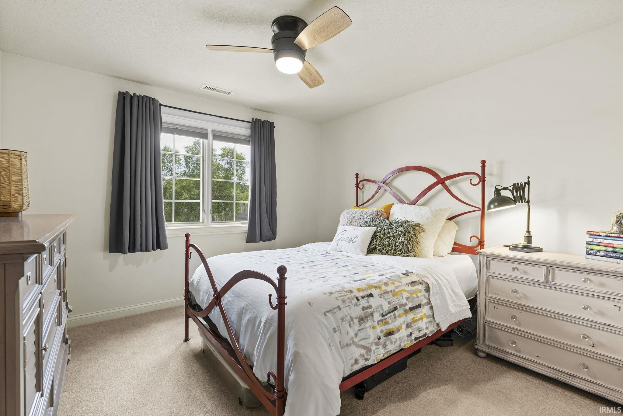 Carpeted room with a ceiling fan featuring a central light fixture