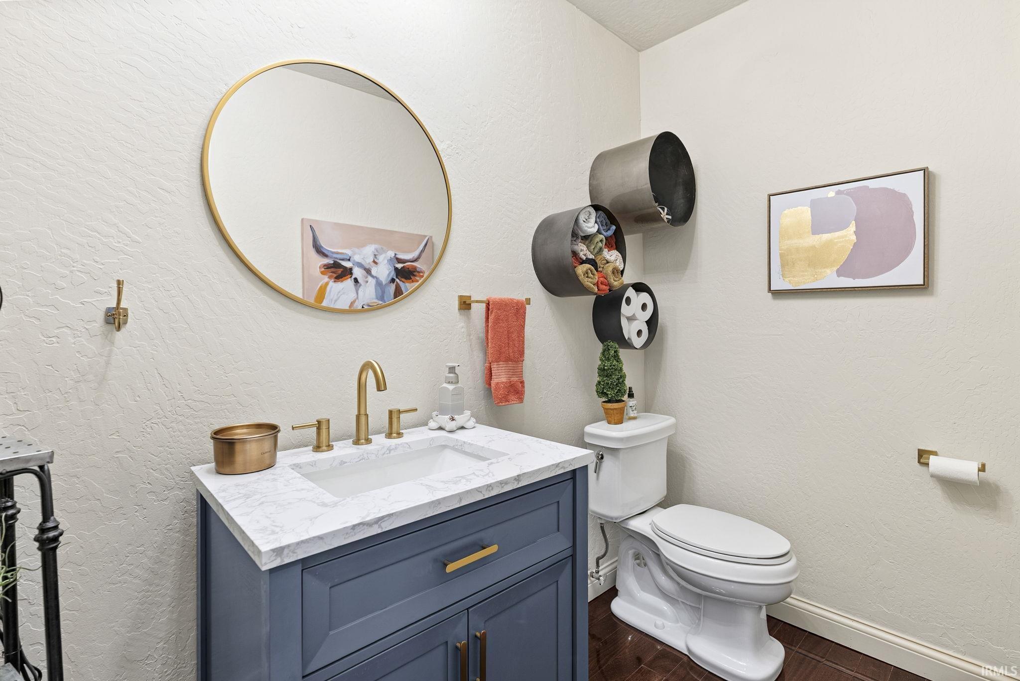 Bathroom featuring a blue vanity with a white countertop and rectangular sink, complemented by gold-finish fixtures