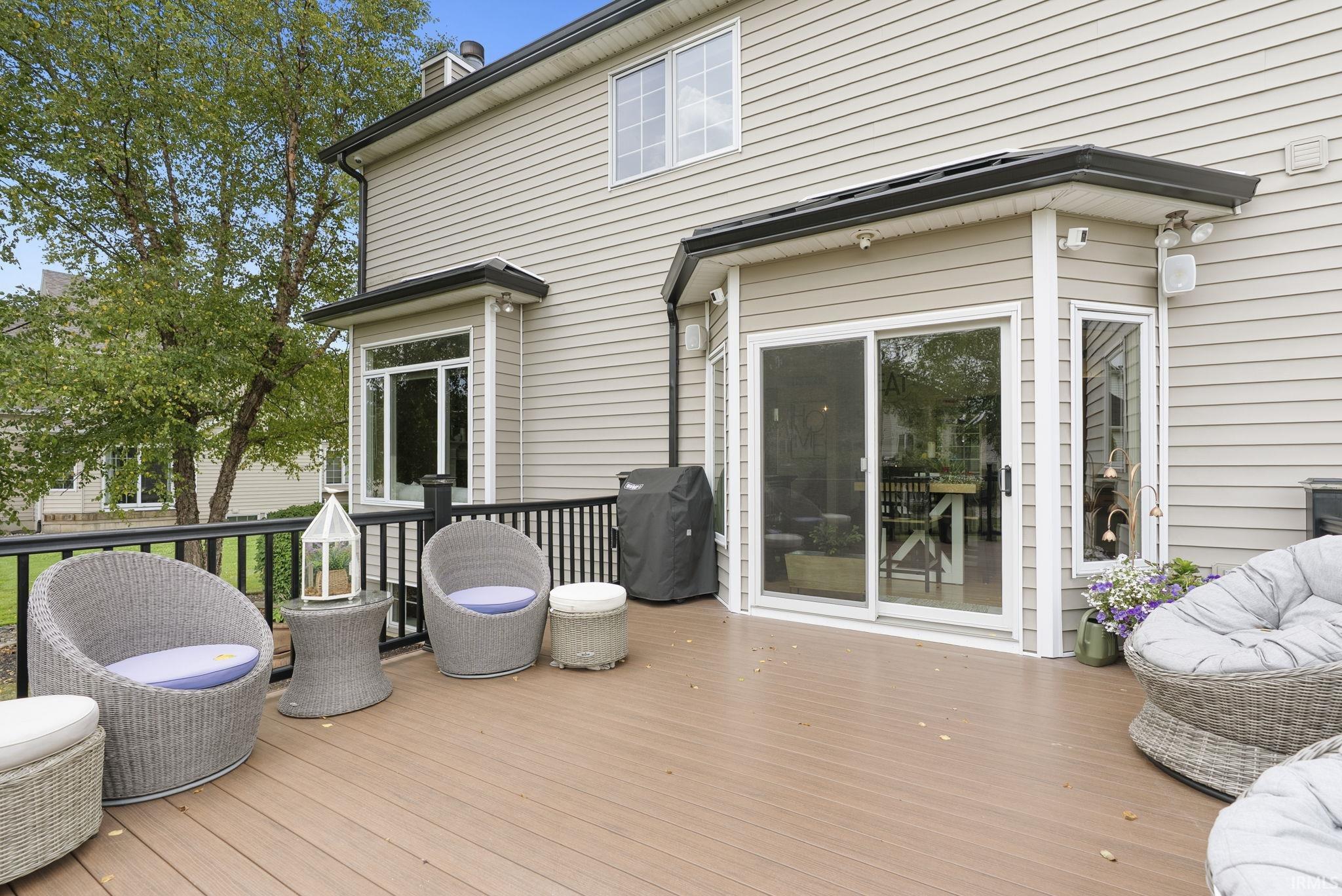 Expansive composite deck featuring composite decking material, multiple seating areas with built-in conversation spaces, and direct access to the residence through sliding glass doors