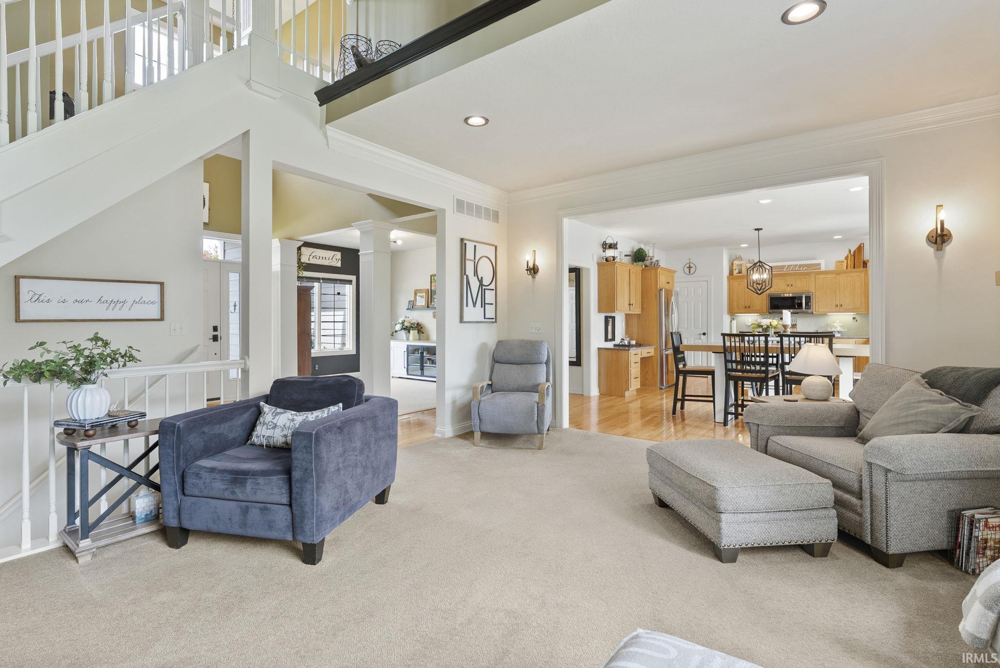 Expansive living space featuring a carpeted floor, recessed lighting, and wall-mounted sconces