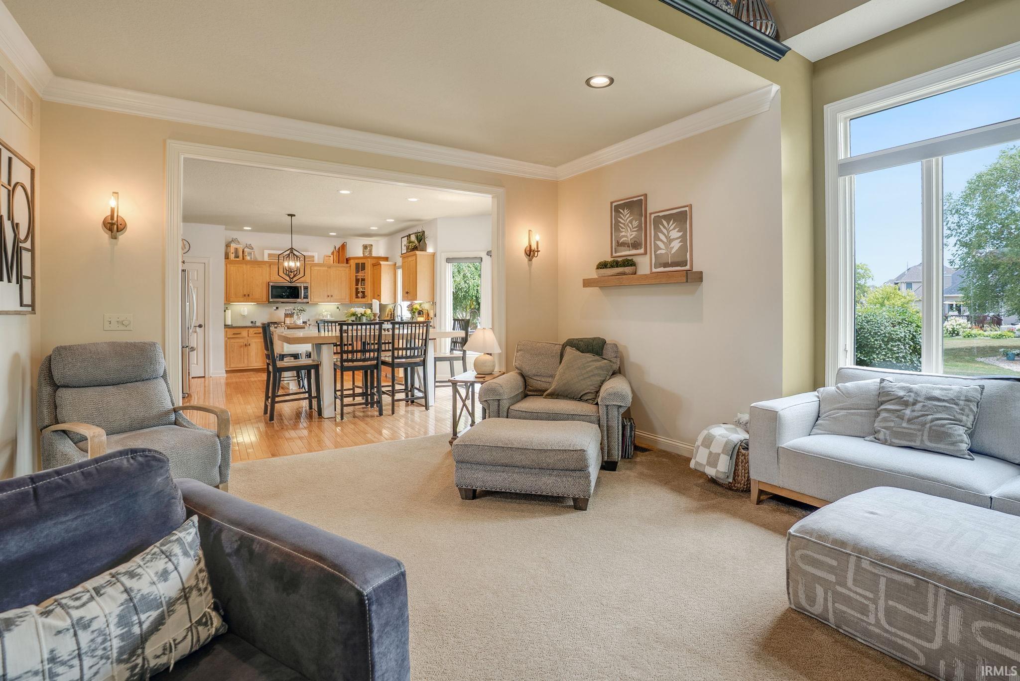 Spacious living area featuring neutral carpeting and large windows