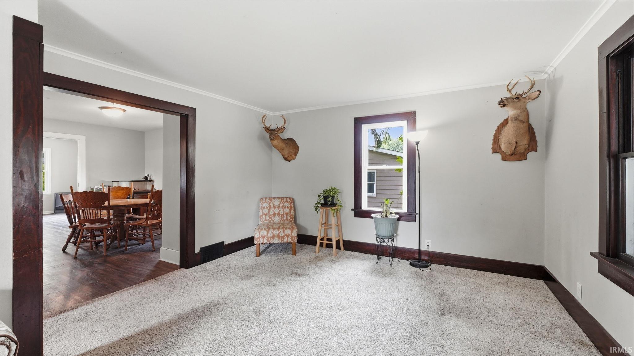 Spacious room with light-toned wall paint and white crown molding
