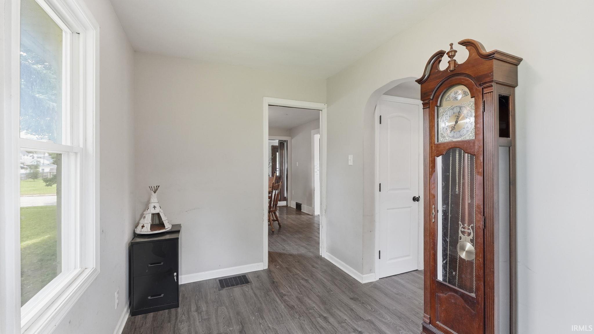 Interior space featuring wood-finish flooring, light grey wall paint, and white trim