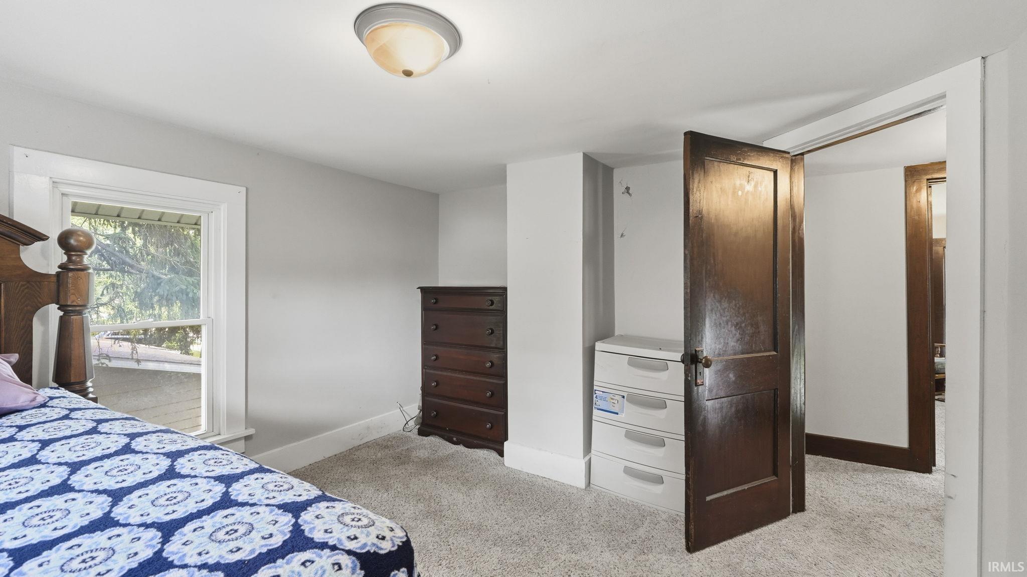 Interior room with light gray walls, white trim, and light-colored carpet flooring