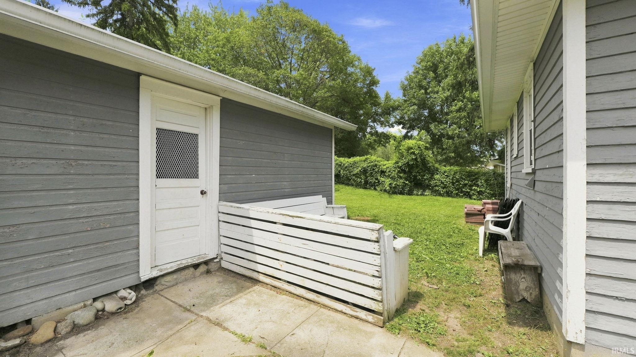 Exterior utility structure with gray horizontal siding and white trim