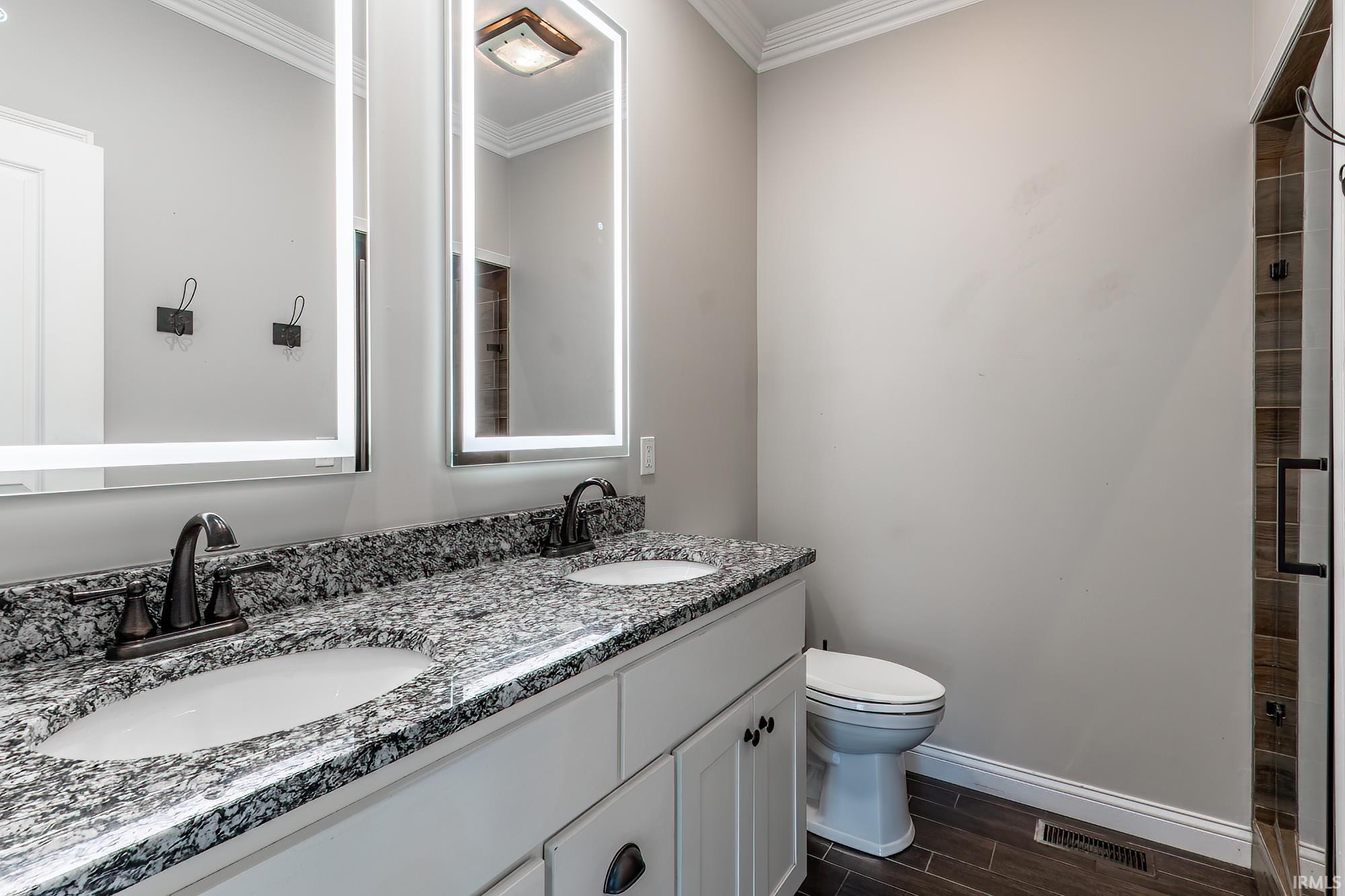 Dual vanity featuring a speckled countertop, undermount sinks, and bronze-finish faucets
